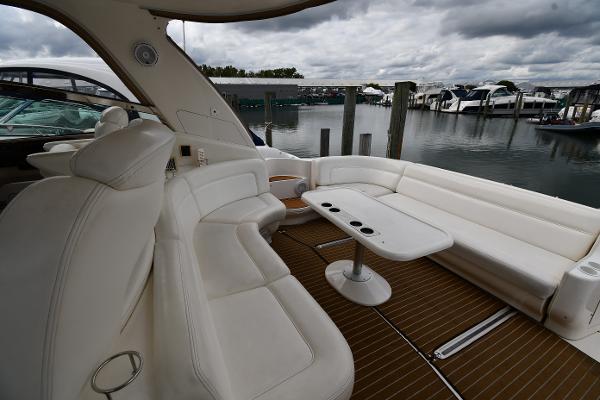 2003 Sea Ray 460 Sundancer yacht interior with white seating and table, docked at marina.