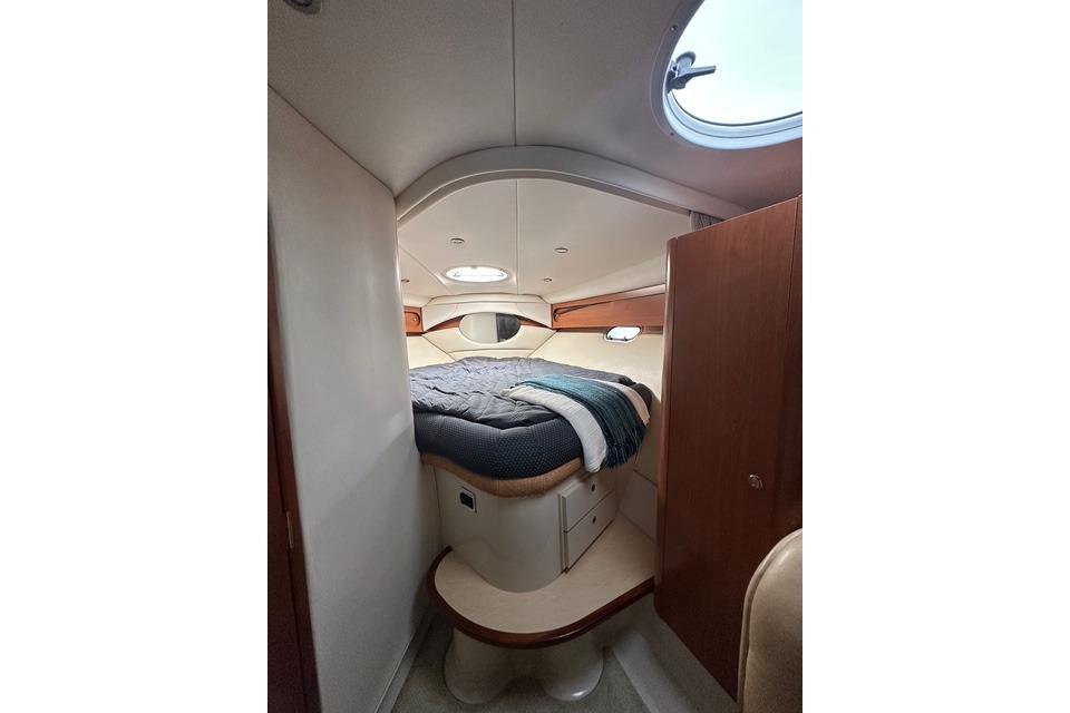 Interior cabin of 2003 Four Winns 378 Vista yacht with cozy bed and porthole.