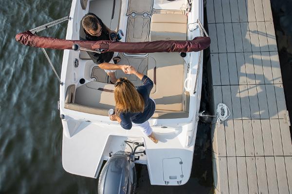2025 Hurricane SunDeck Sport 205 OB at dock, two people boarding.