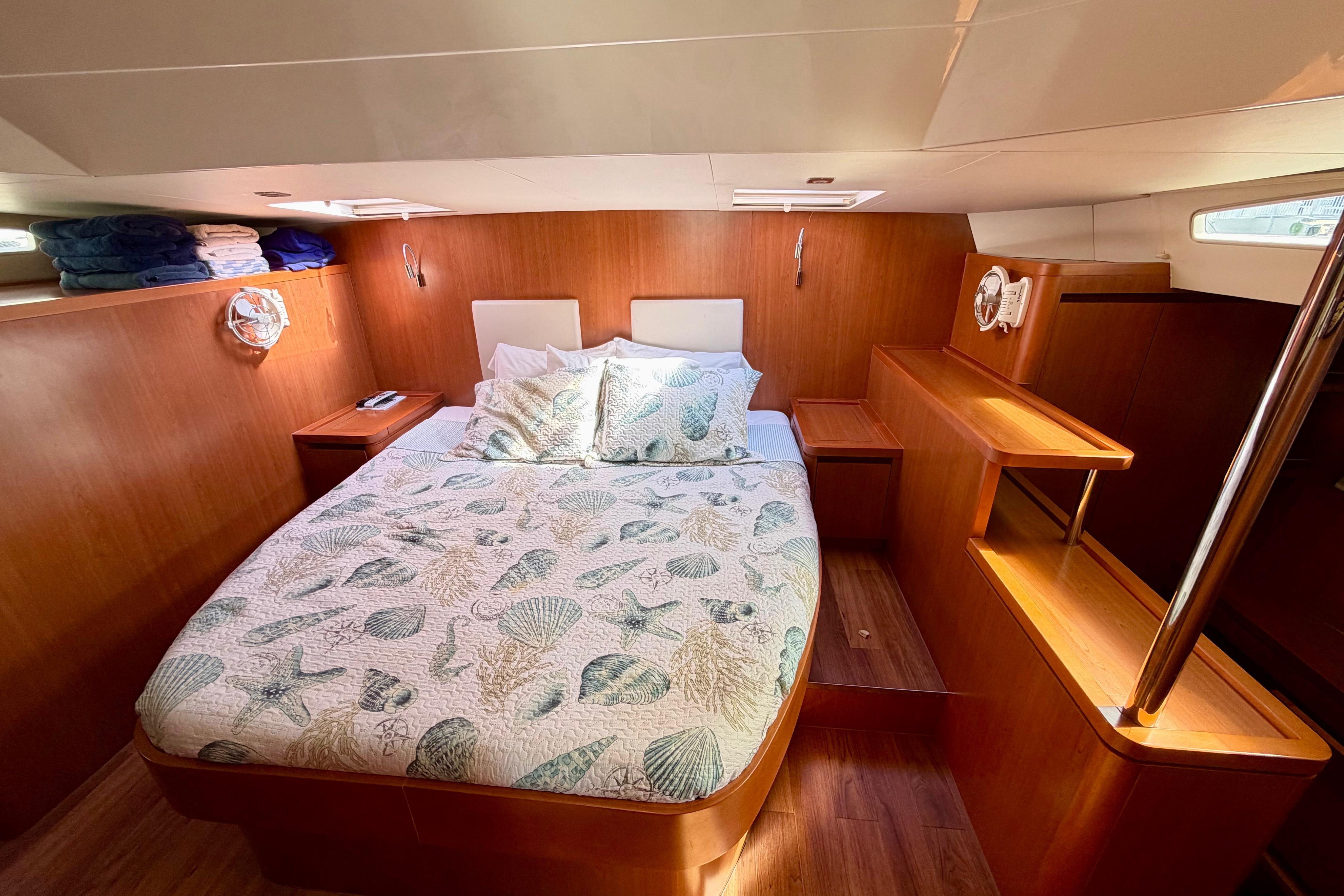 Luxurious cabin interior of 2017 Aquila 44 Yacht with cozy bedding and wooden finish.