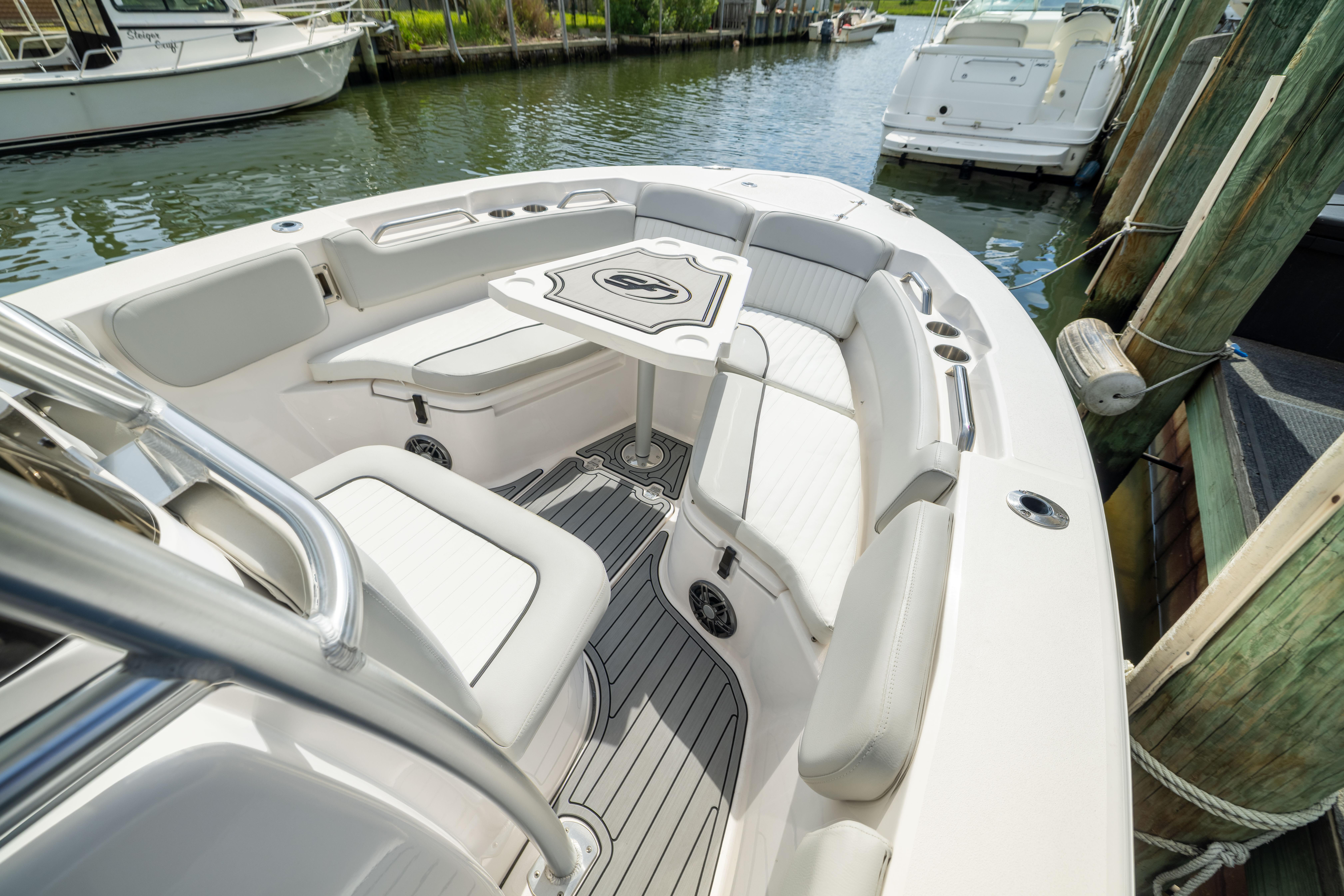 2023 Sea Fox 228 Commander boat interior with seating and table, docked in a marina.