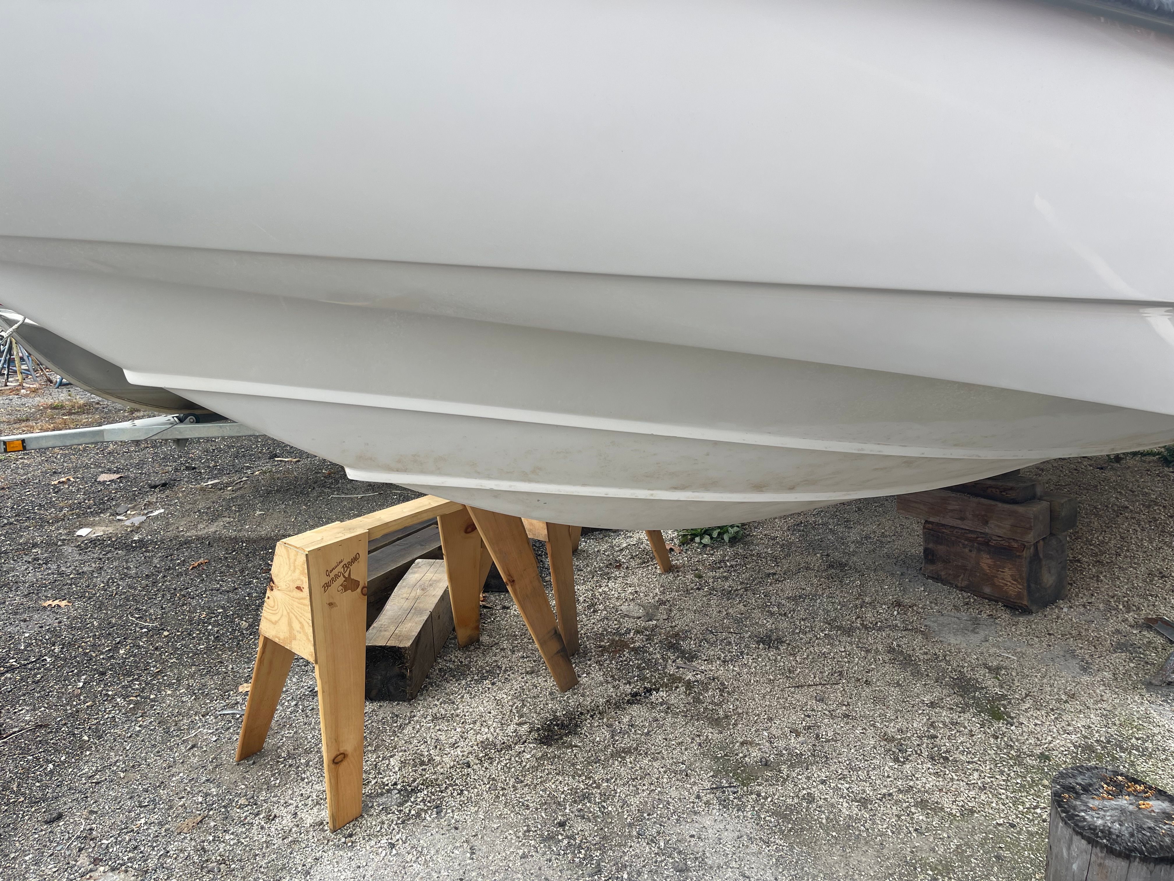 Hull of a 2001 Boston Whaler 26 Conquest boat on stands.