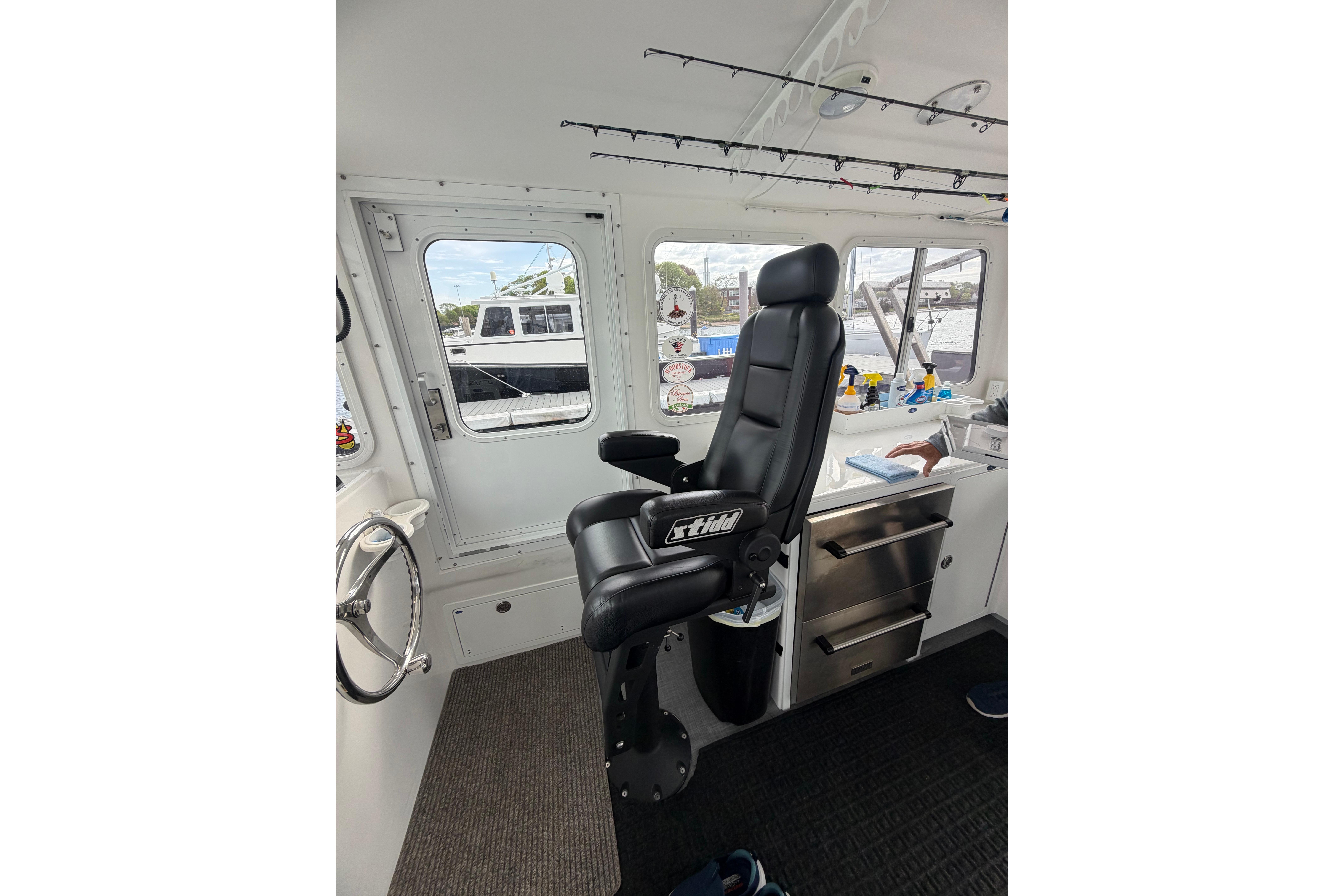 Interior of 2018 H&H Marine Osmond Beal boat with captain's chair and control panel.