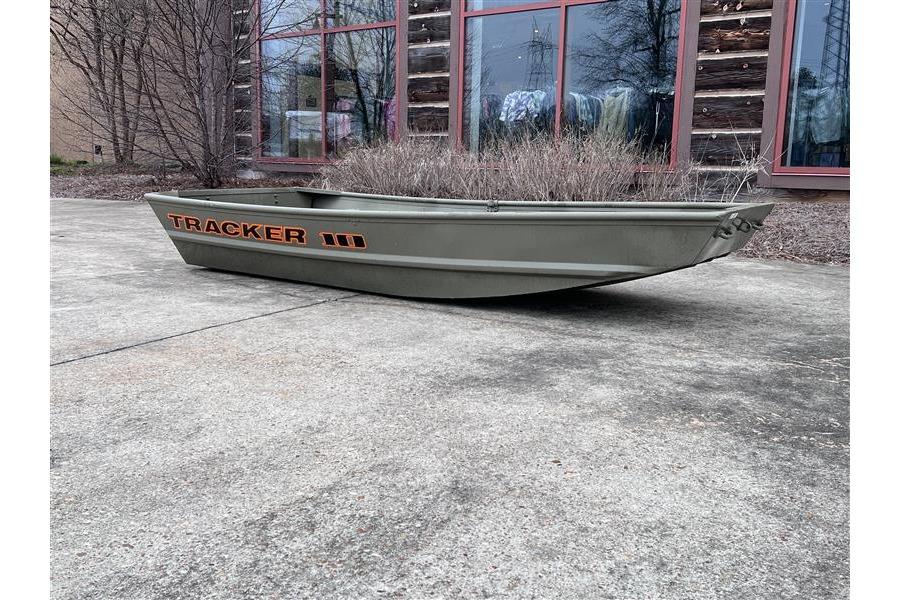 2026 Tracker Grizzly 10 Jon boat on concrete, rustic building background.