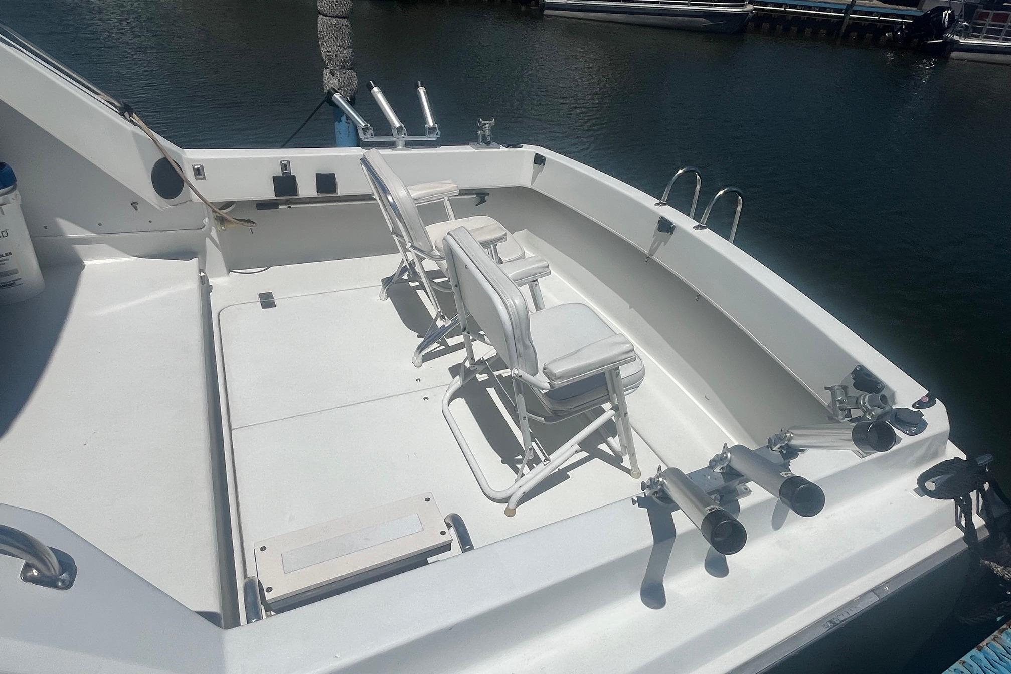 1988 Seafox 29 Flybridge boat deck with chairs and fishing rod holders.