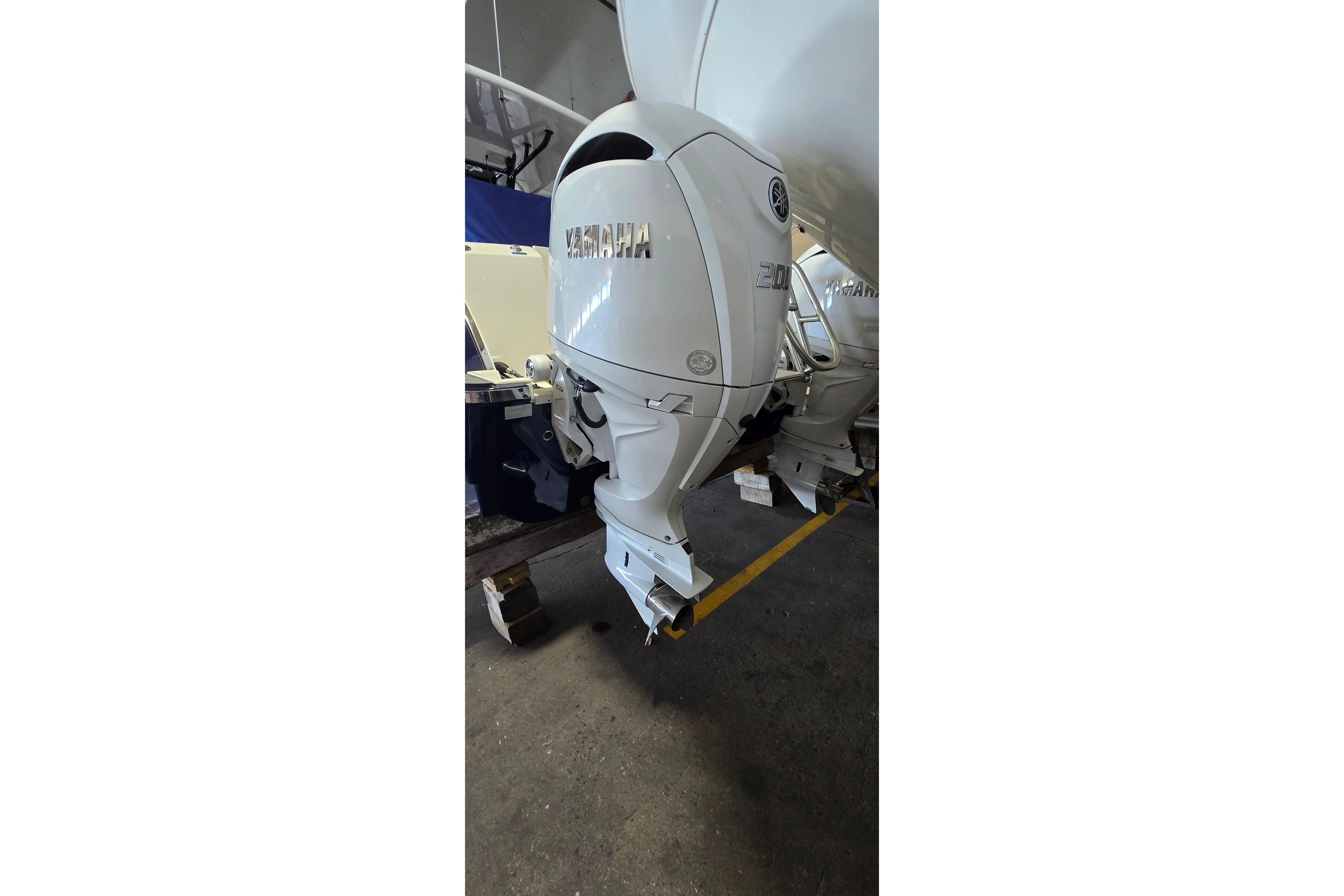 2024 WorldCat 280 CC-X boat with Yamaha outboard motor in a garage.