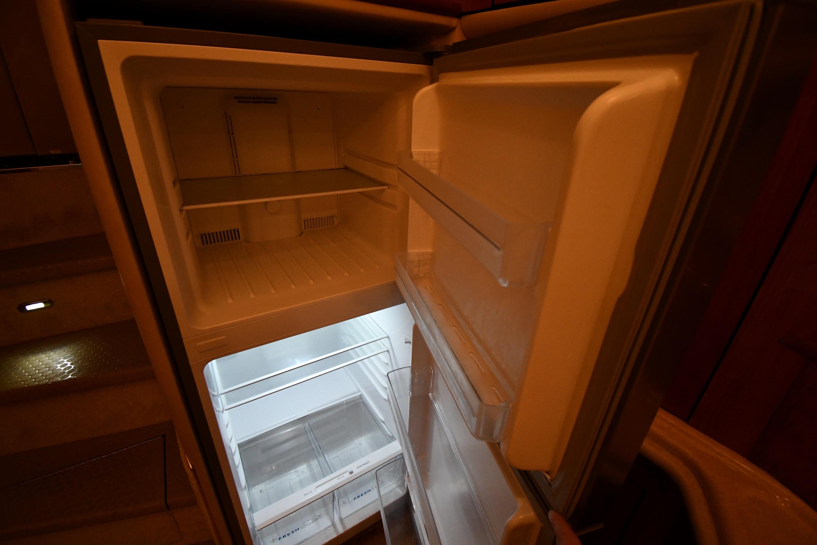 Open refrigerator inside 2001 Sea Ray 540 Sundancer yacht, showcasing spacious interior.