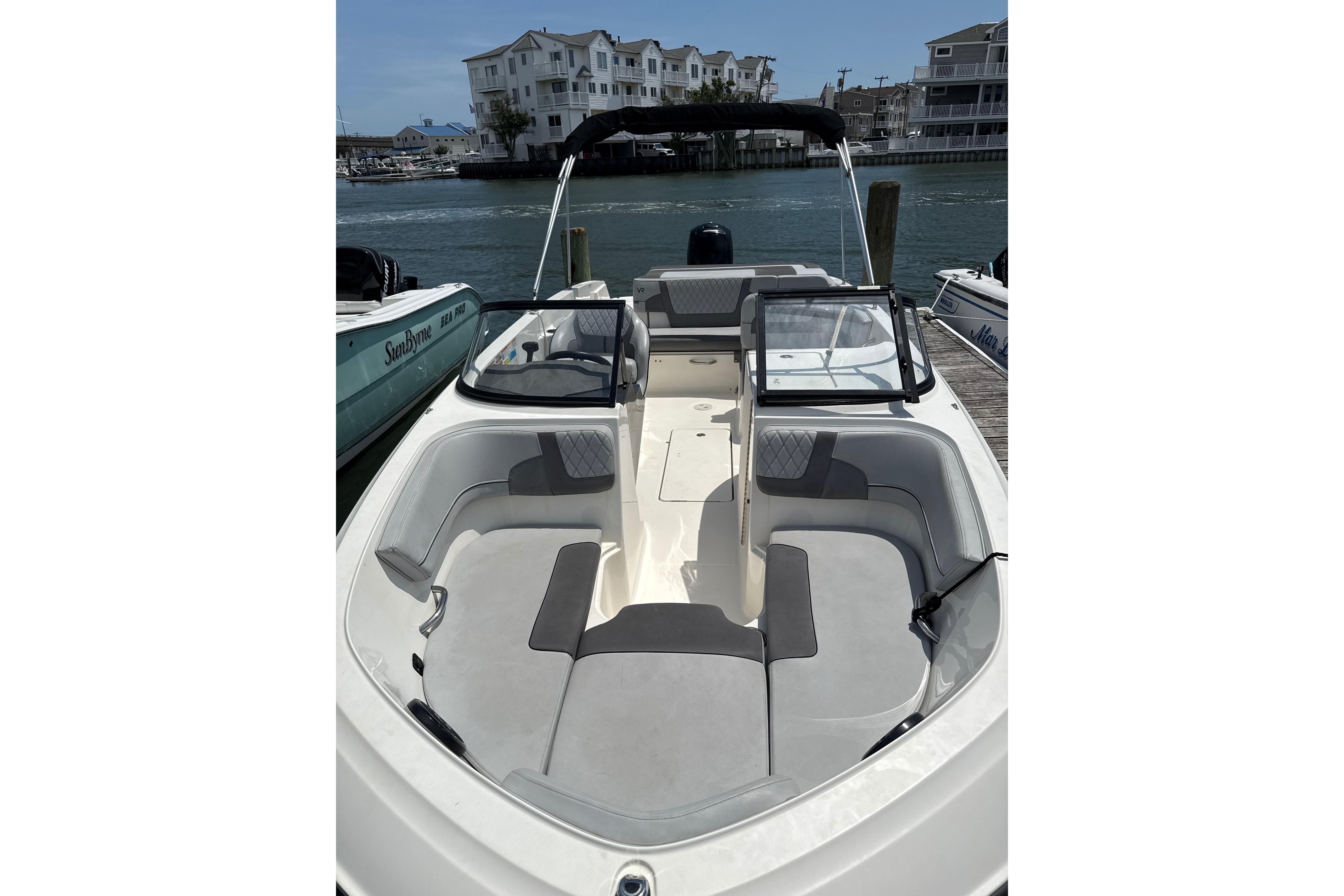 2023 Bayliner VR6 Bowrider OB docked, showcasing spacious seating and sleek design.