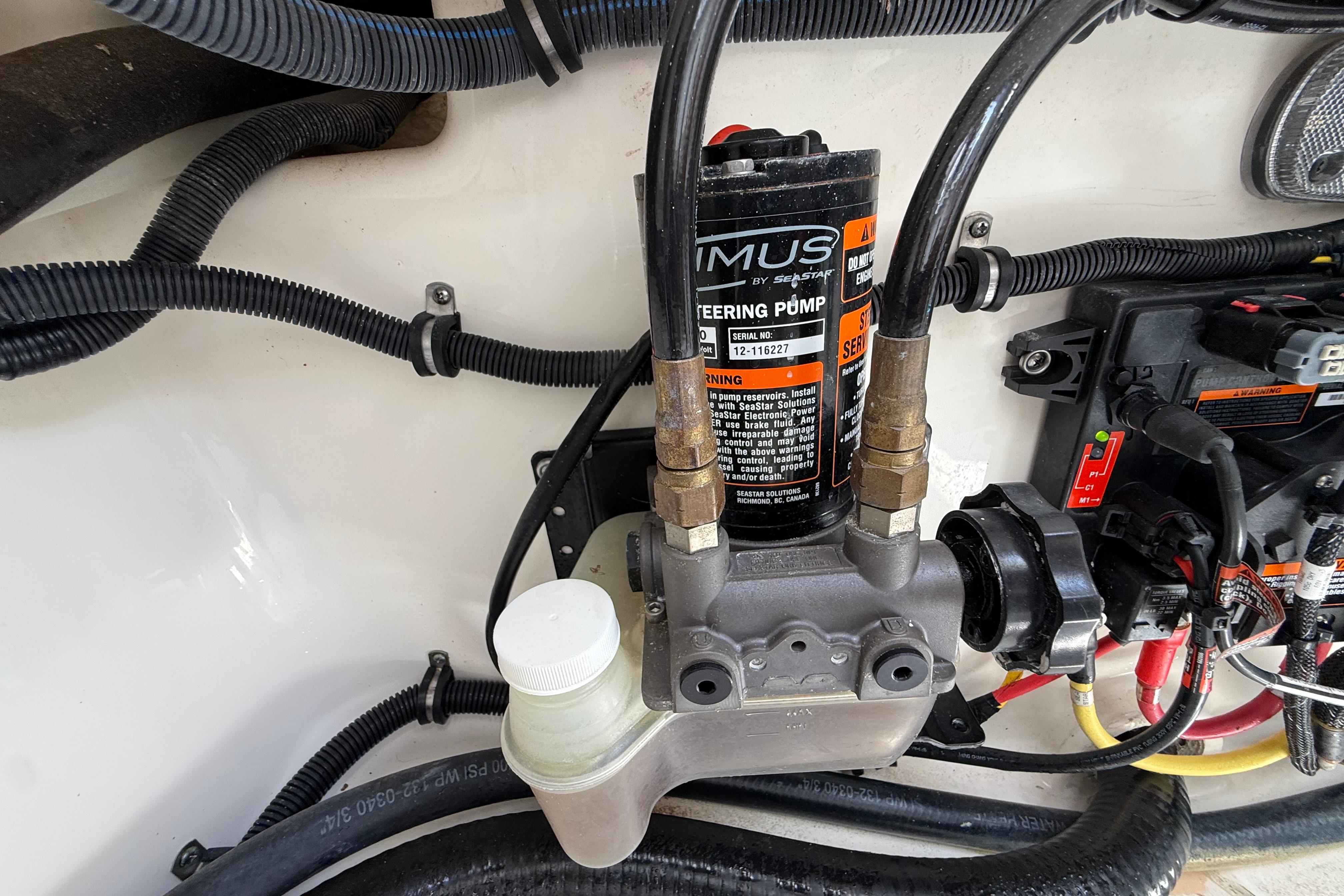 2019 Regulator 26XO steering pump system with wiring and hydraulic connections.