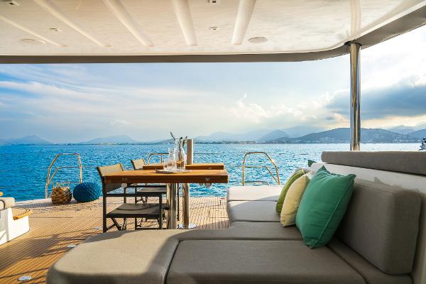 Luxurious Lagoon 60 yacht interior with ocean view, featuring comfortable seating and dining area, 2025 model.