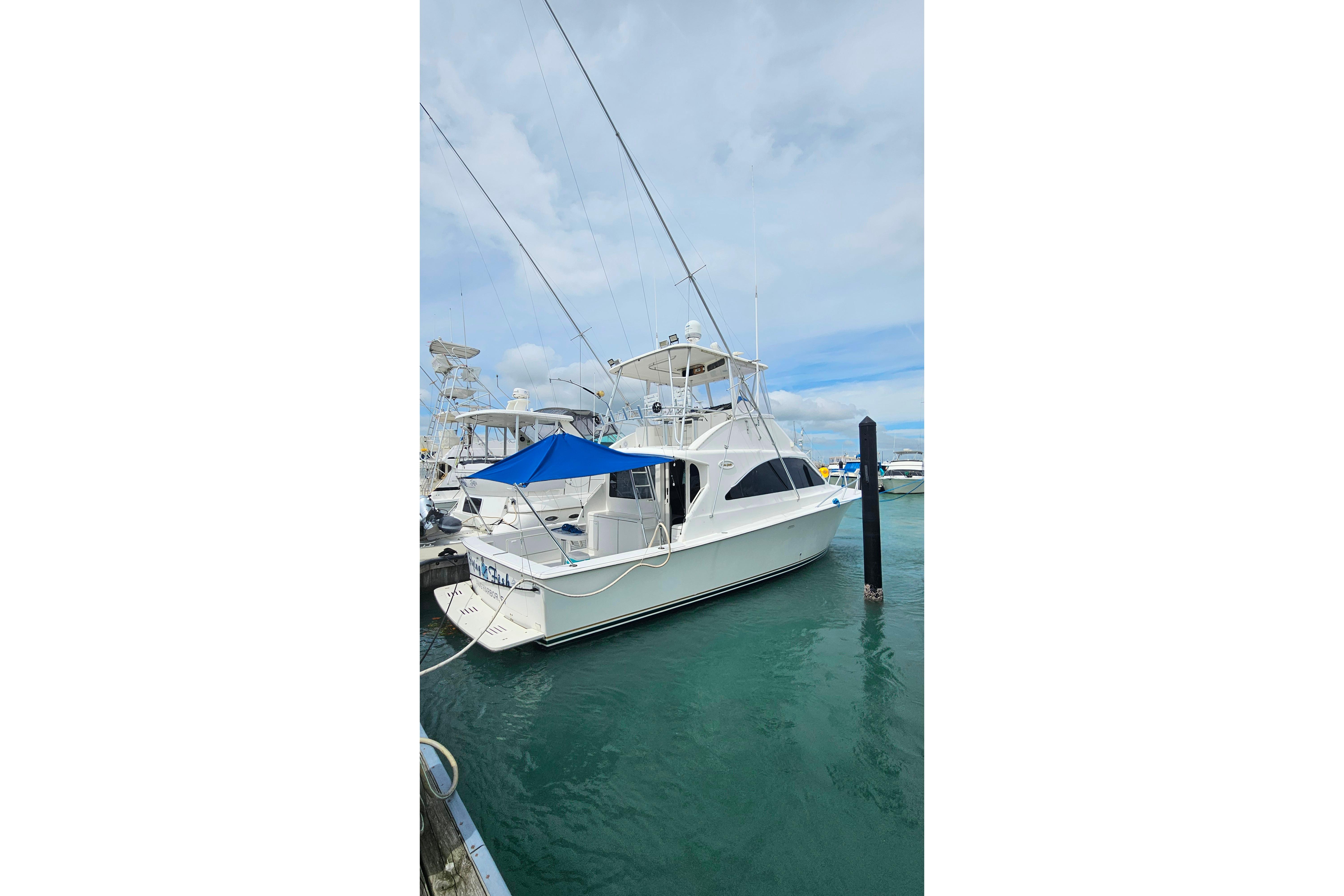 2000 Ocean Yachts 40 Super Sport docked in marina with blue canopy.