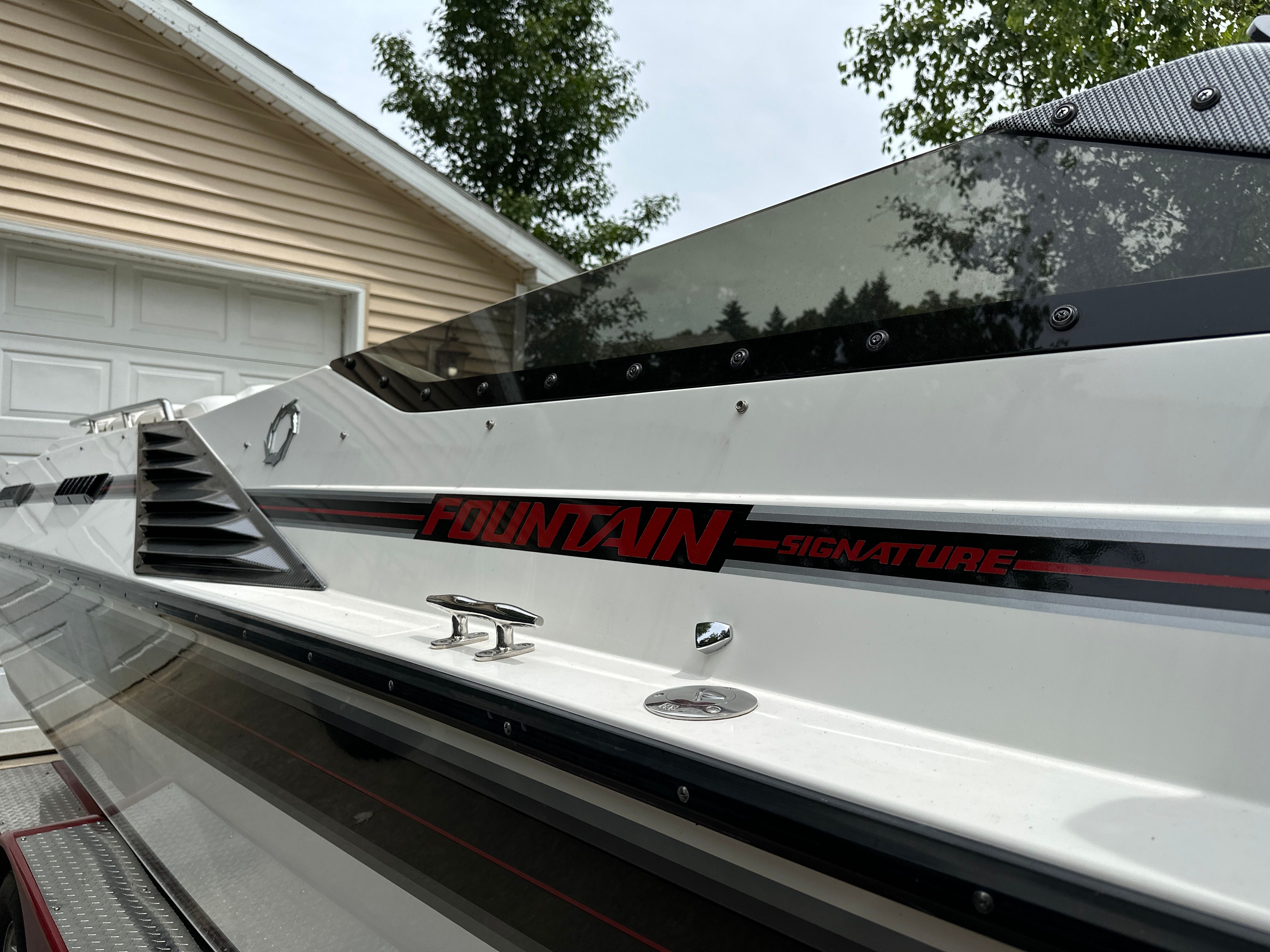 Close-up of a white boat with "Fountain Signature" lettering on the side.