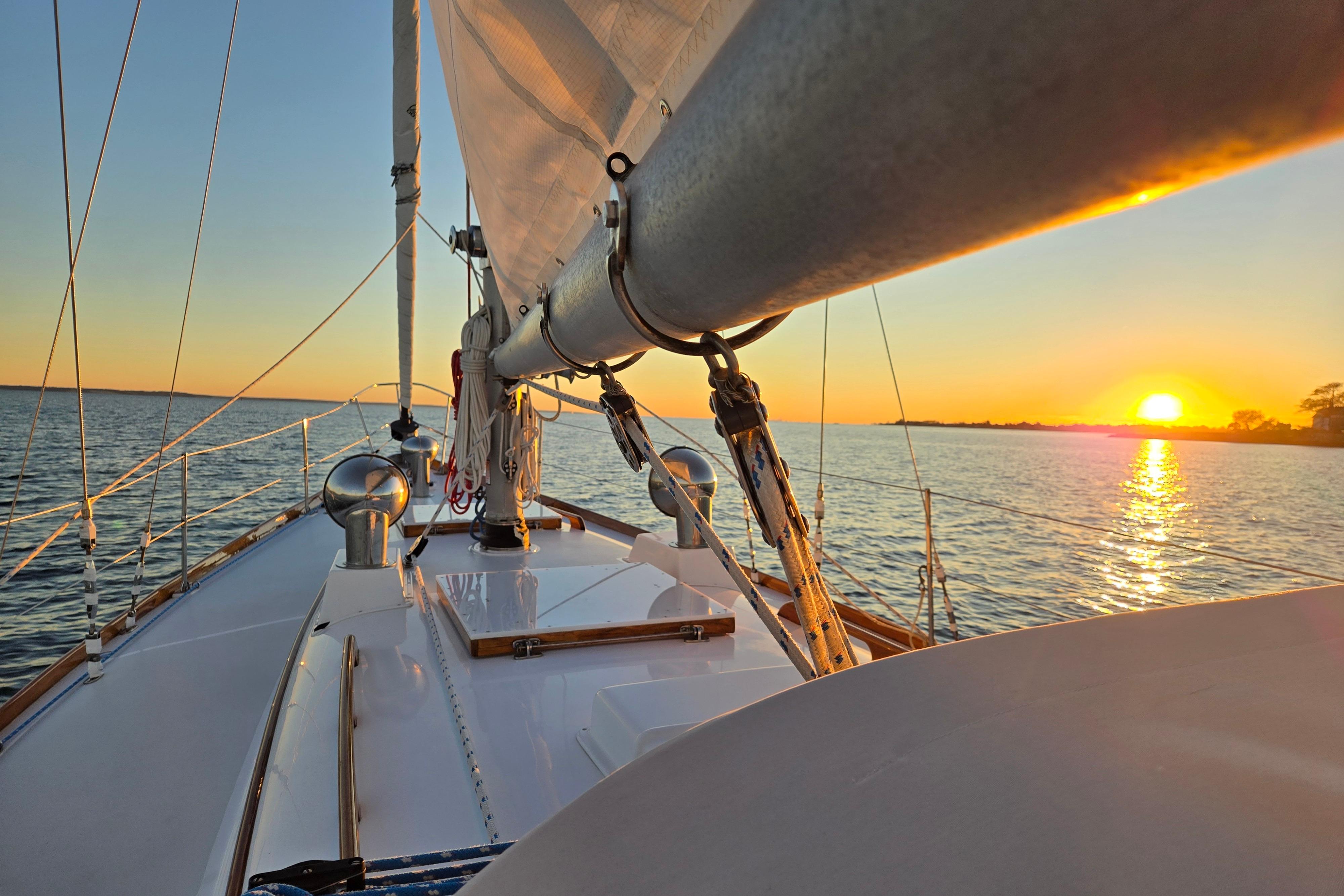 1970 Hinckley Bermuda 40 sailboat at sunset on calm waters.