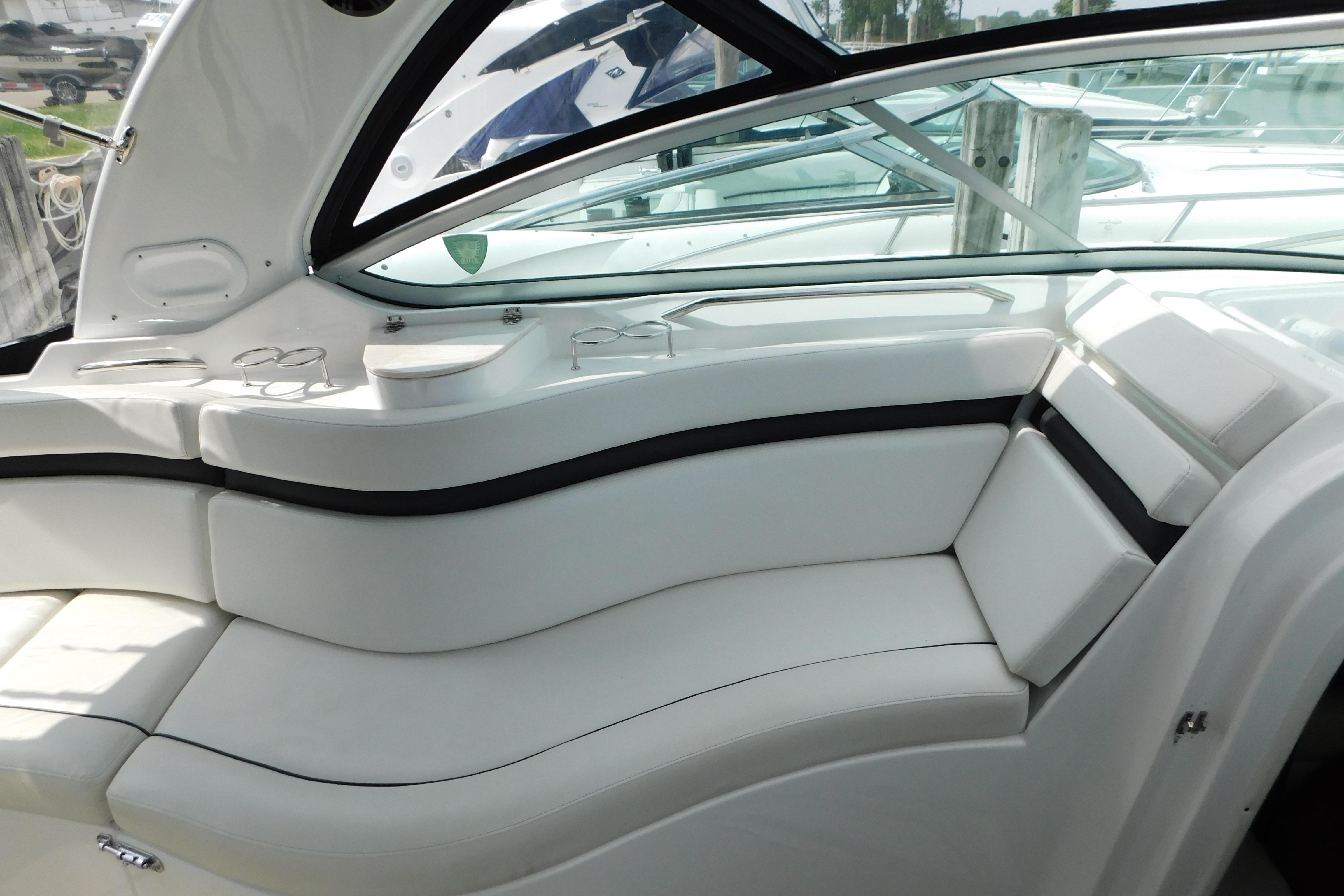 Interior seating of a 2017 Rinker EX 320 boat, featuring white cushioned seats and cup holders.