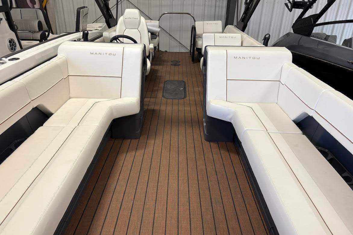 Interior of 2023 Manitou EXPLORE 26 SHP 575 boat with white seating and wood flooring.