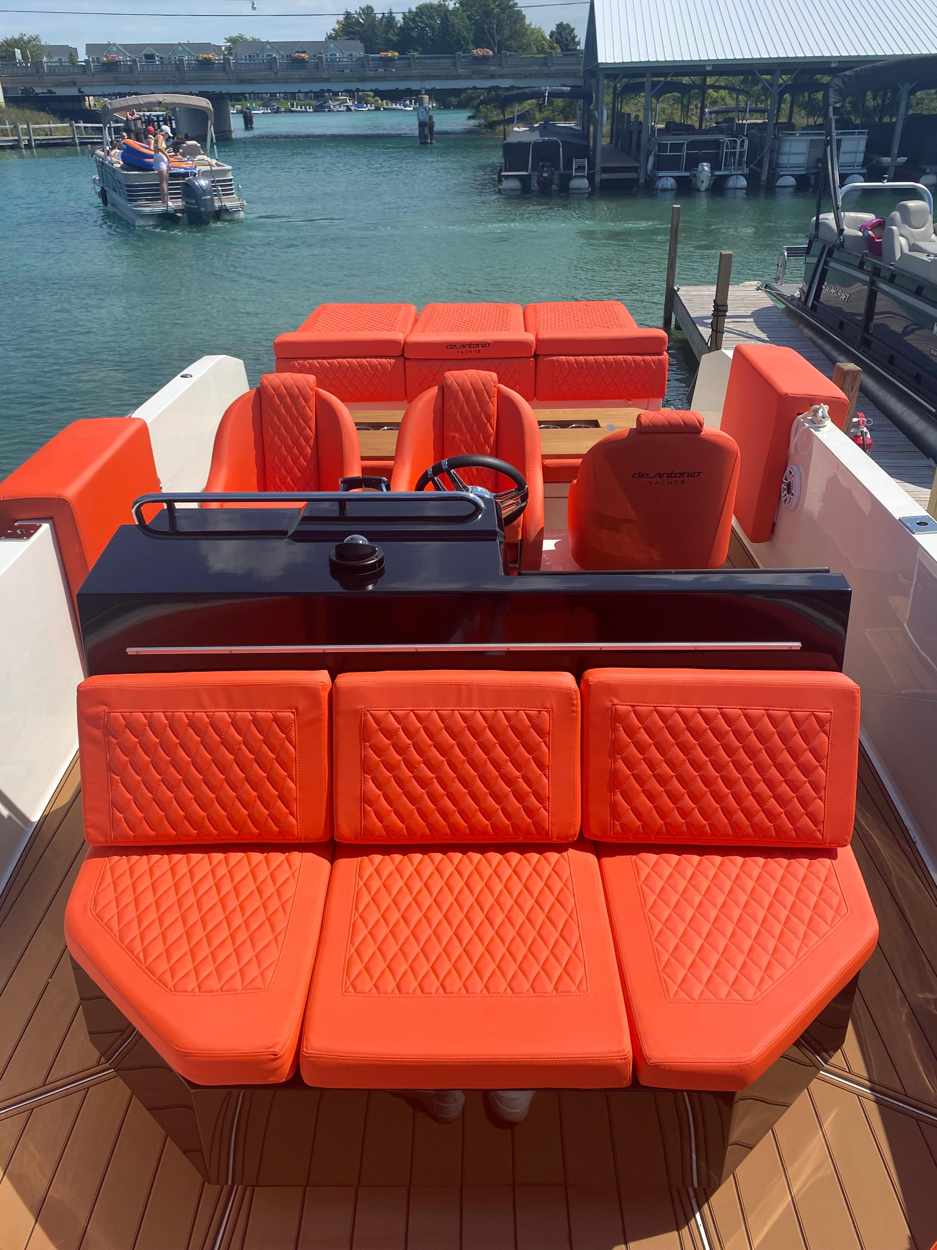 De Antonio Yachts D 28 2020 model with vibrant orange seating, docked at a marina.