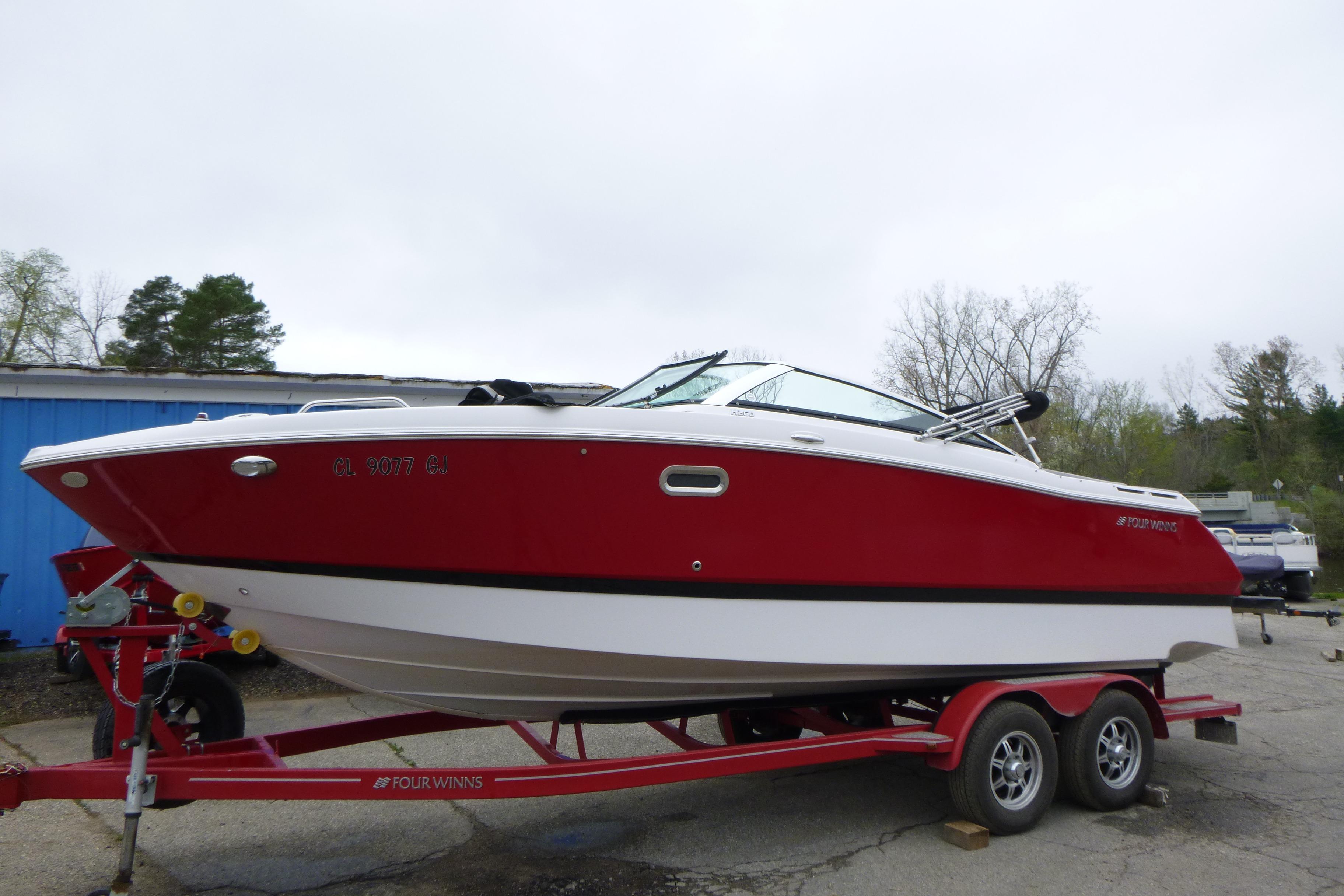 2017 Four Winns H260 boat in red and white on a trailer.