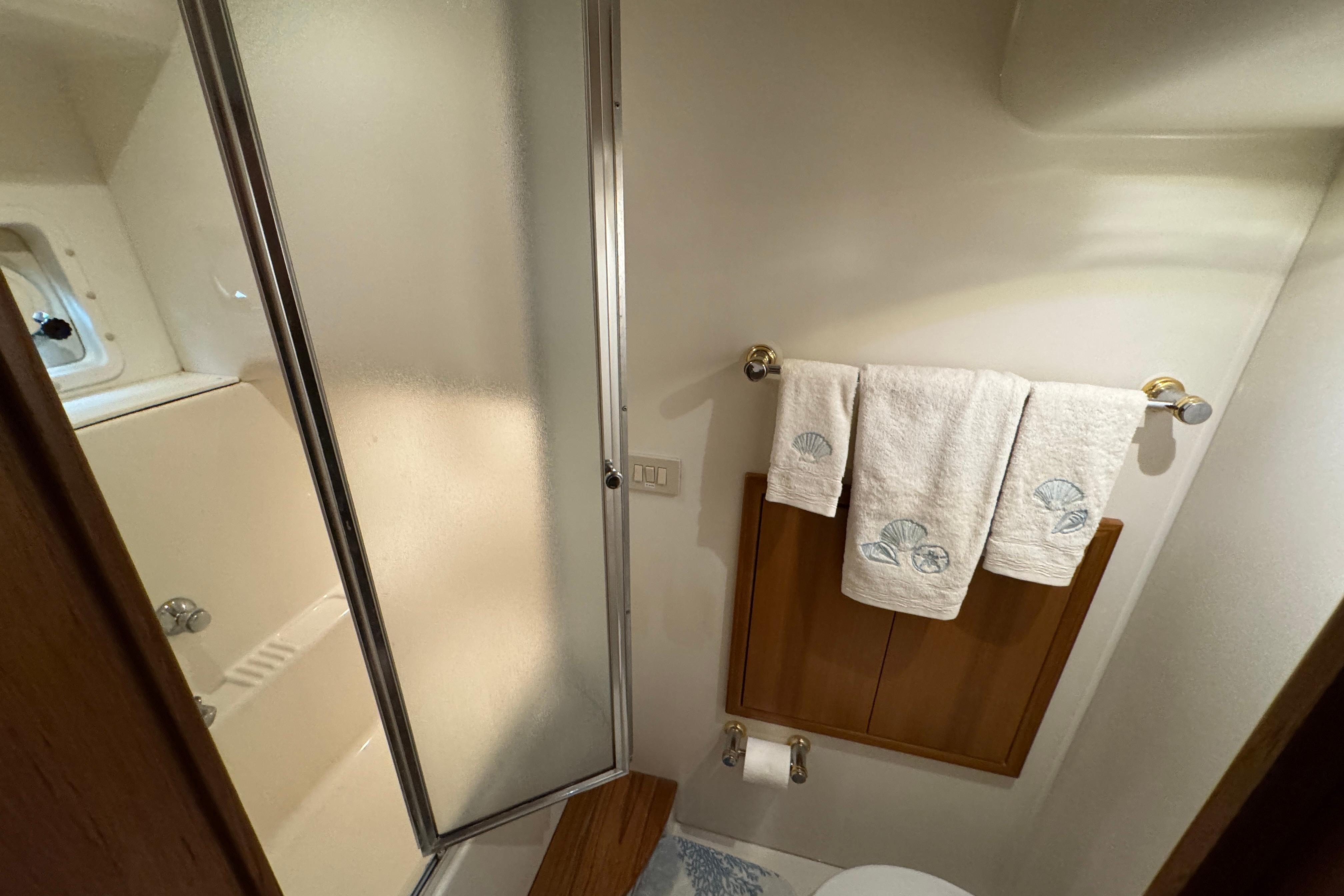 Bathroom interior of 1998 Bayliner 5788 Pilot House Motoryacht with shower and towels.