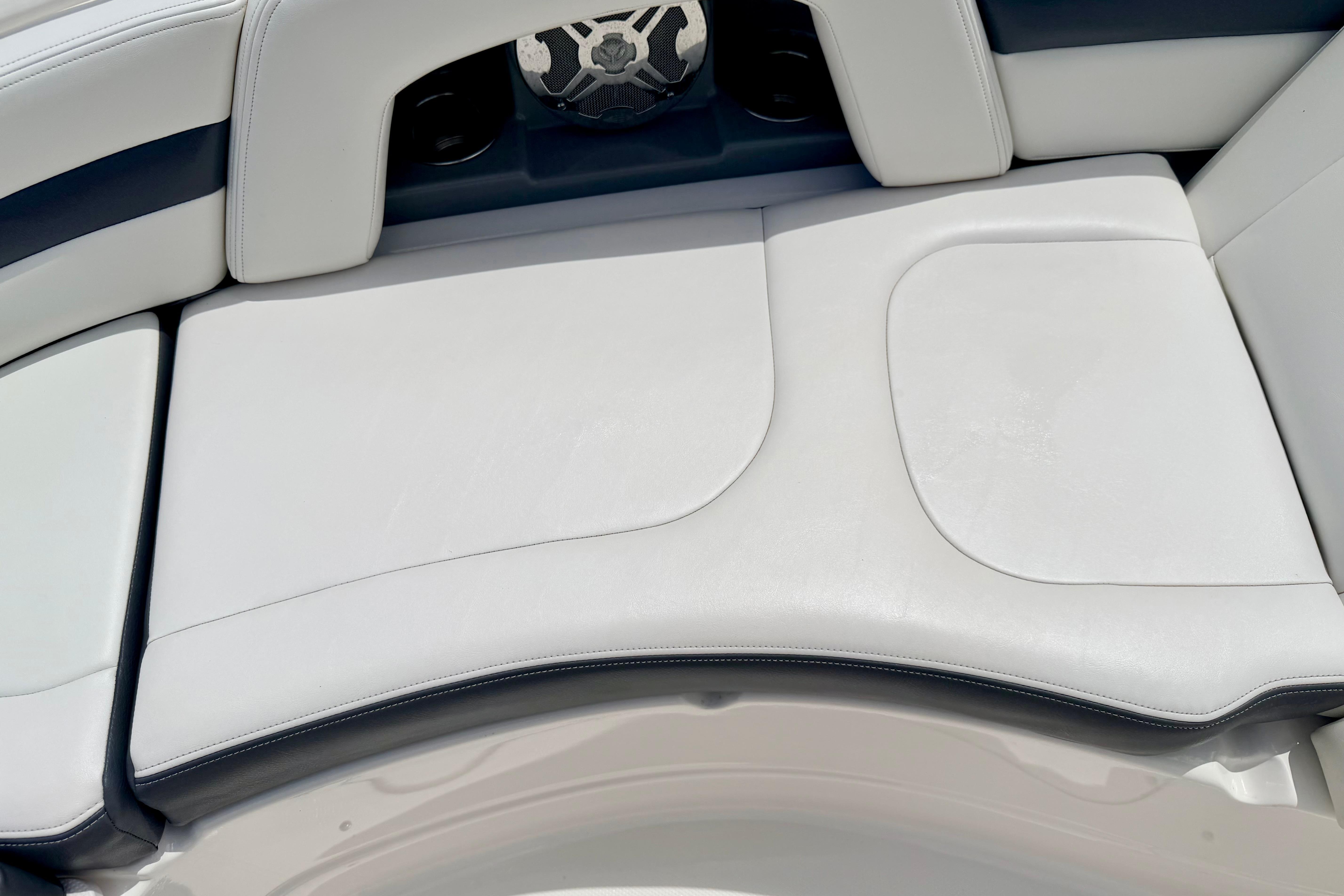 2015 Chaparral Sunesta 264 boat interior with white cushioned seating and speaker detail.