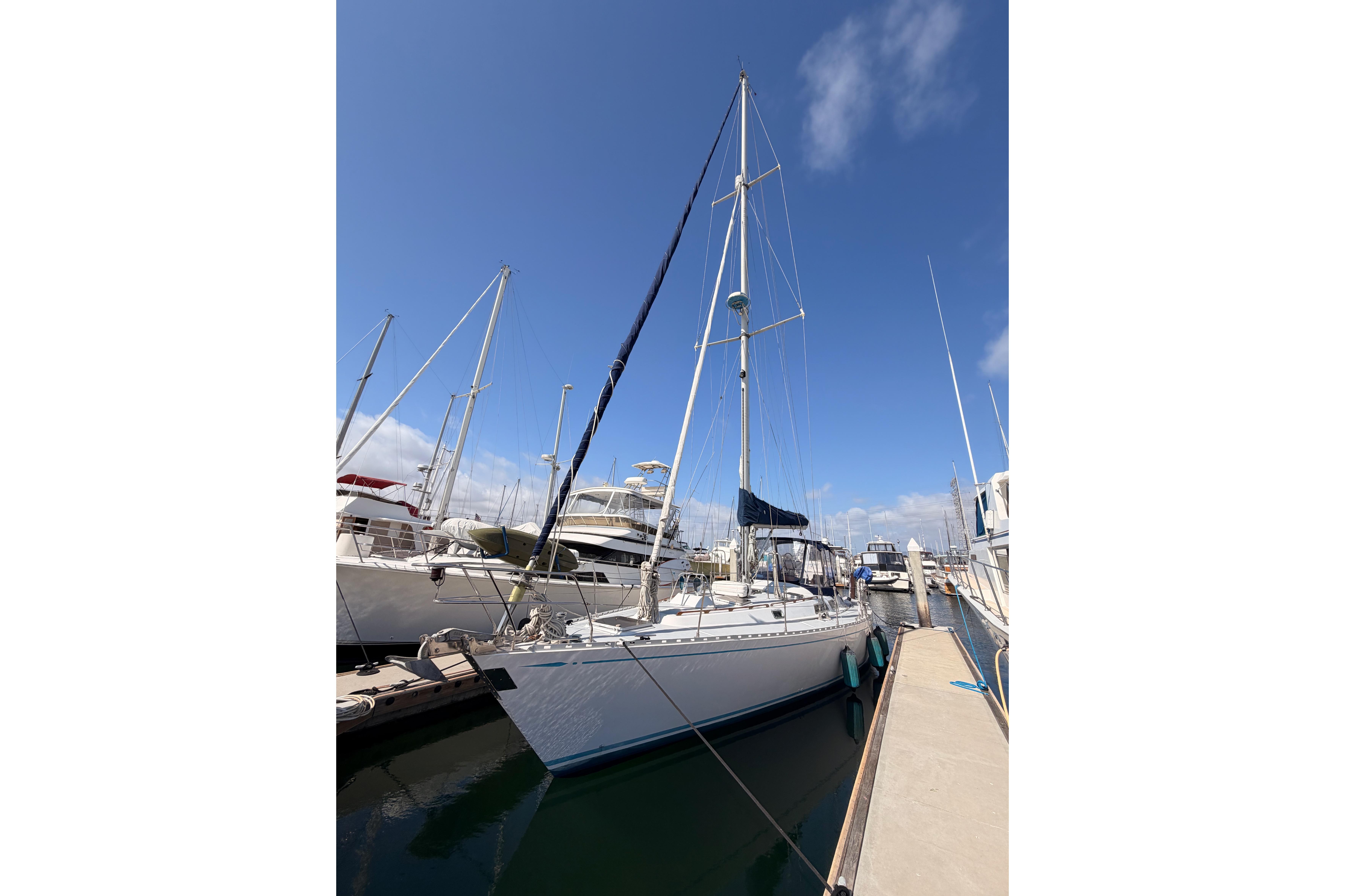 Sailboat docked at marina, Hylas 51 model, 1991, under clear blue sky.
