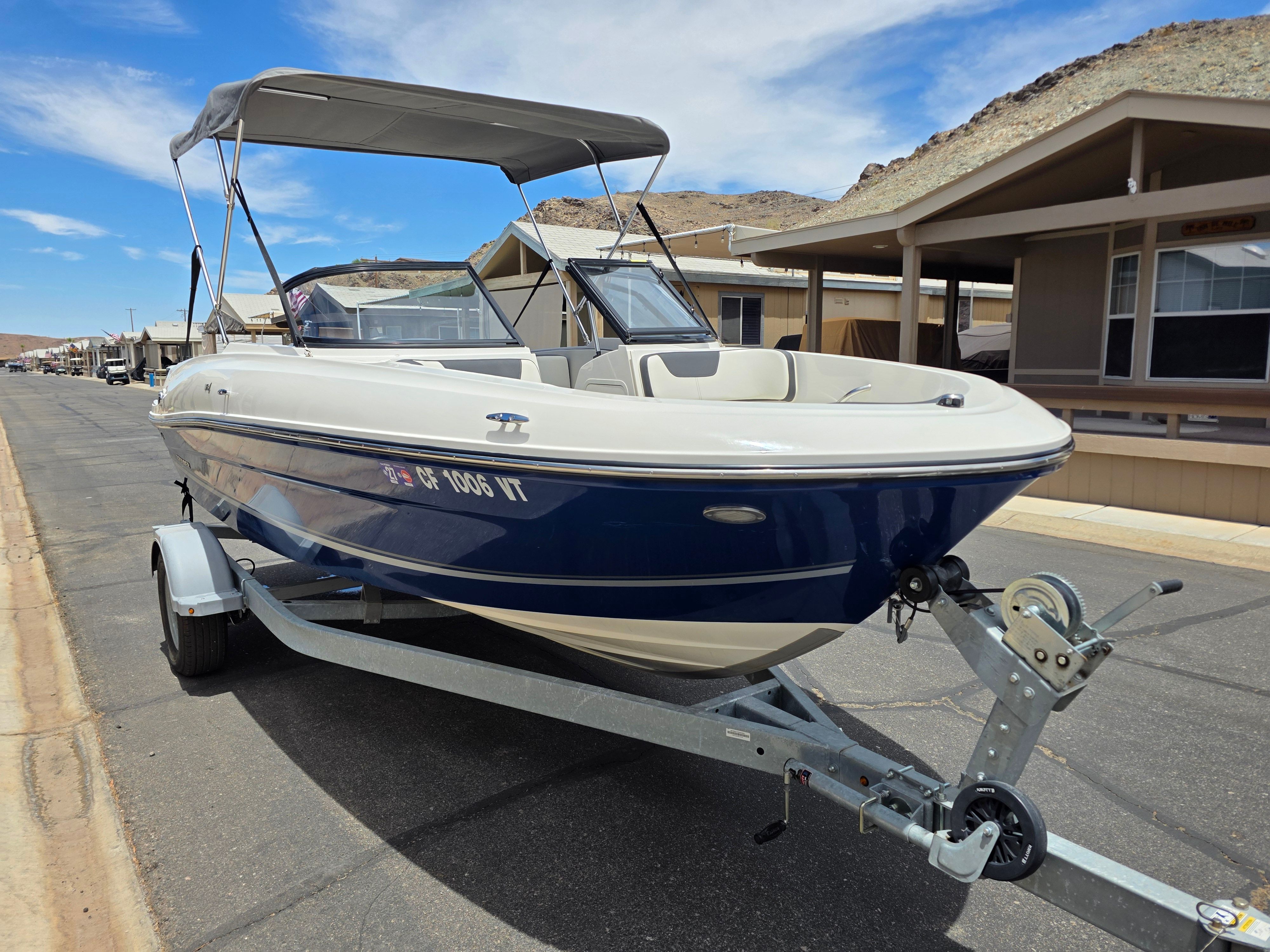 A 2021 Bayliner VR4 Bowrider I/O on a trailer in a residential area.