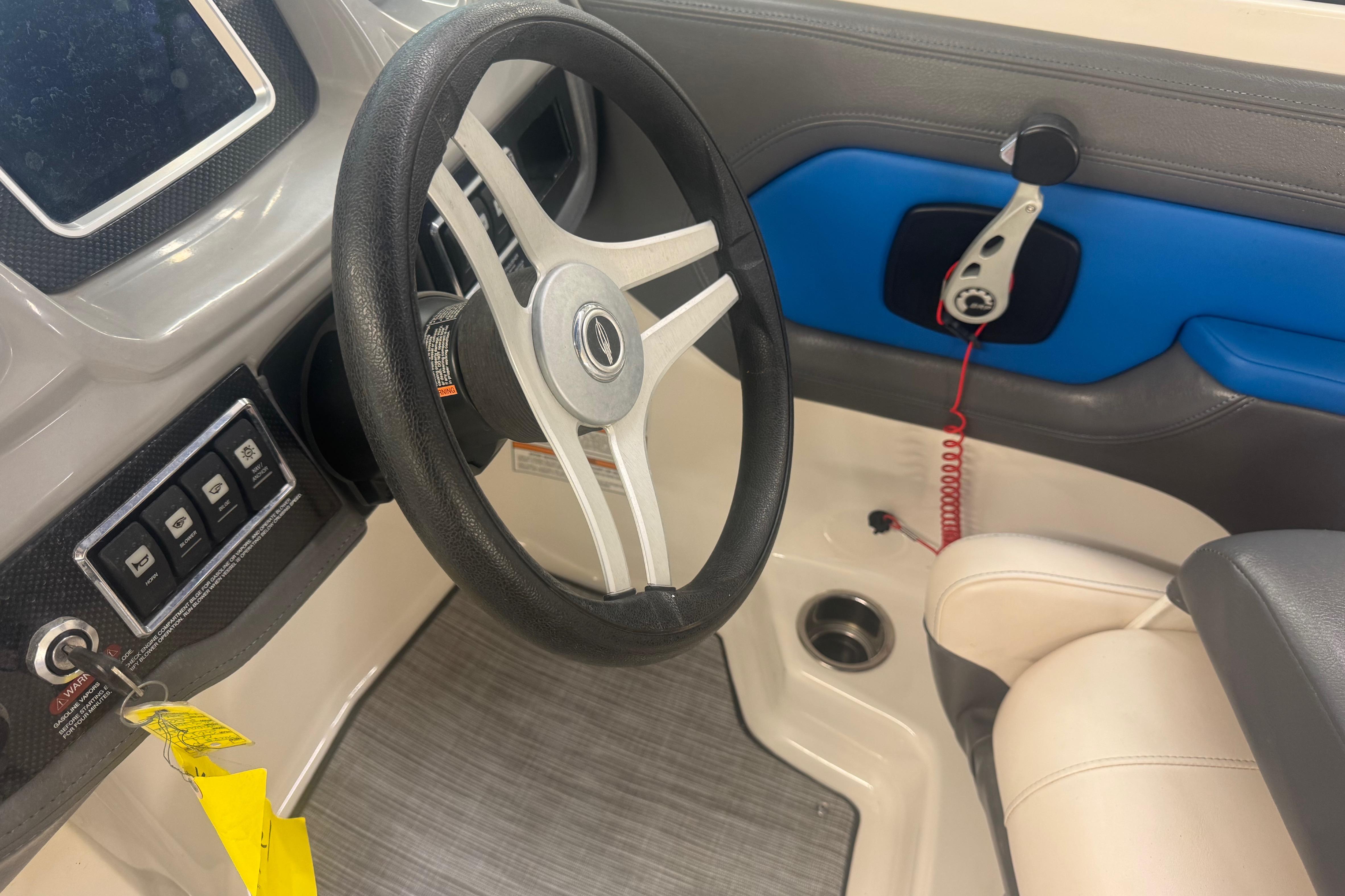 Interior view of 2017 Chaparral Vortex 203 VRX boat cockpit with steering wheel and controls.