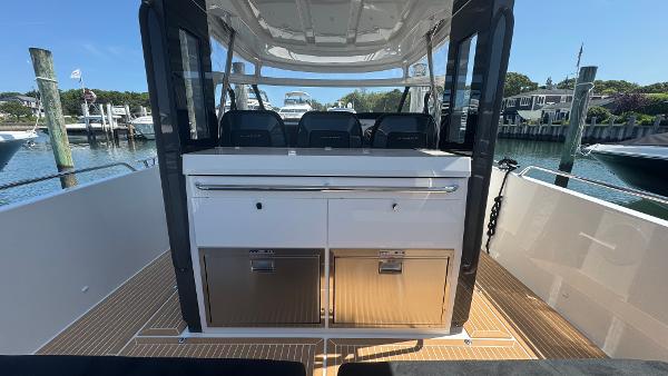 Nimbus T11 2025 boat interior with seating and storage, docked at a marina.