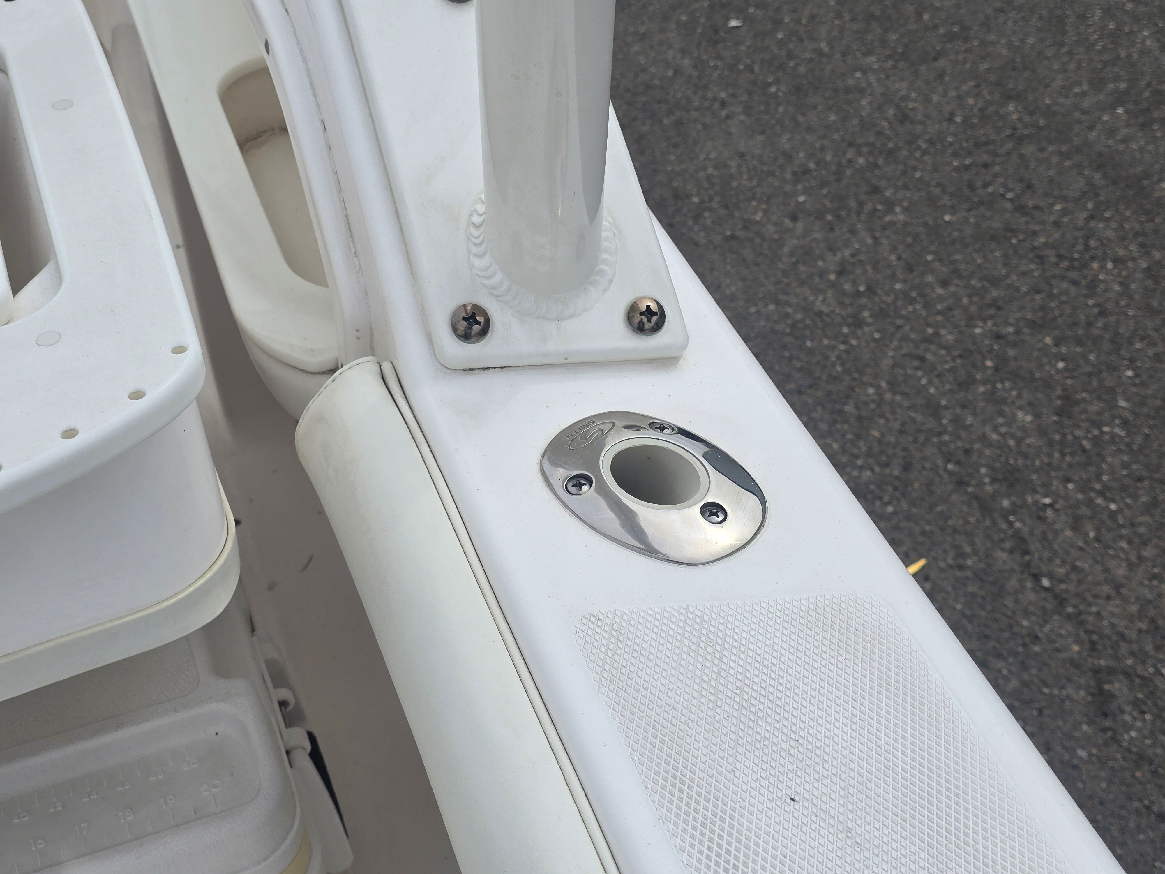 Close-up of a boat part with stainless steel fitting and screws.
