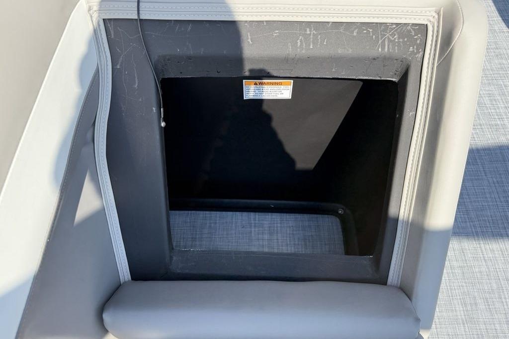 Storage compartment on 2026 Premier 220 Sunscape RF boat, featuring a warning label.