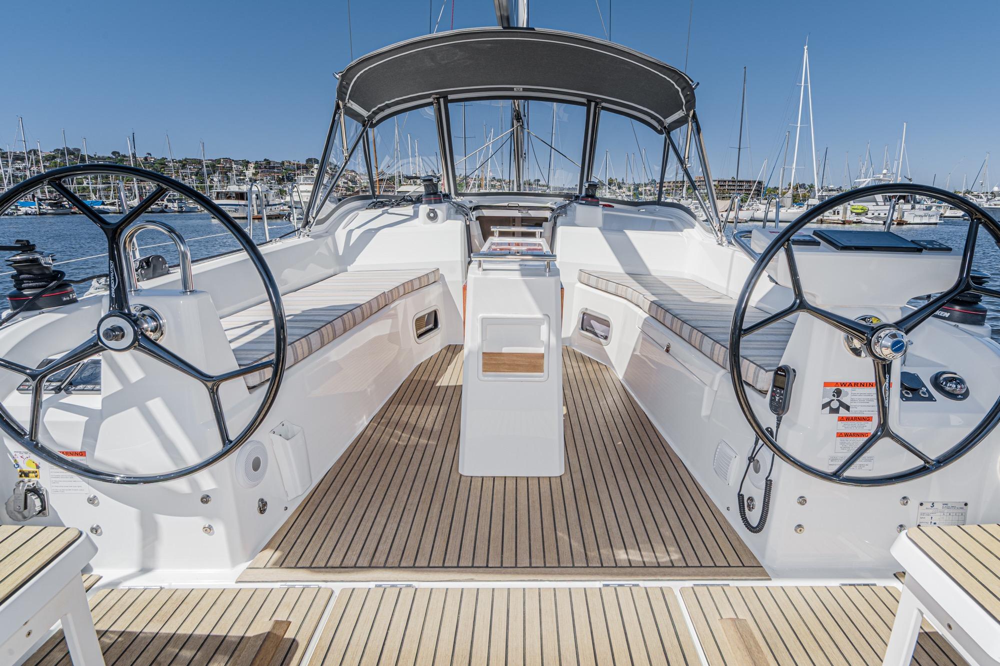 2025 Beneteau Oceanis 37.1 yacht cockpit with dual steering wheels and teak flooring.