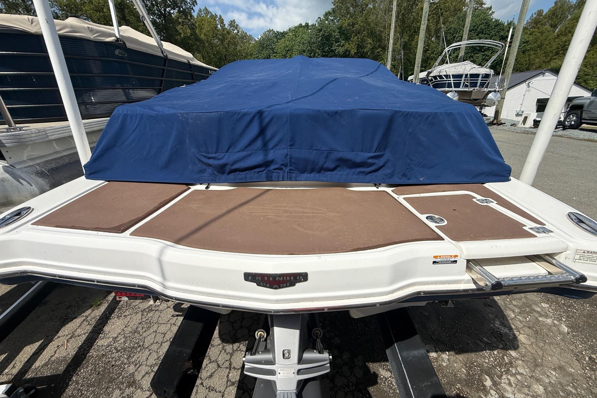 2016 Chaparral 226 SSi Wide Tech boat with blue cover, docked outdoors.