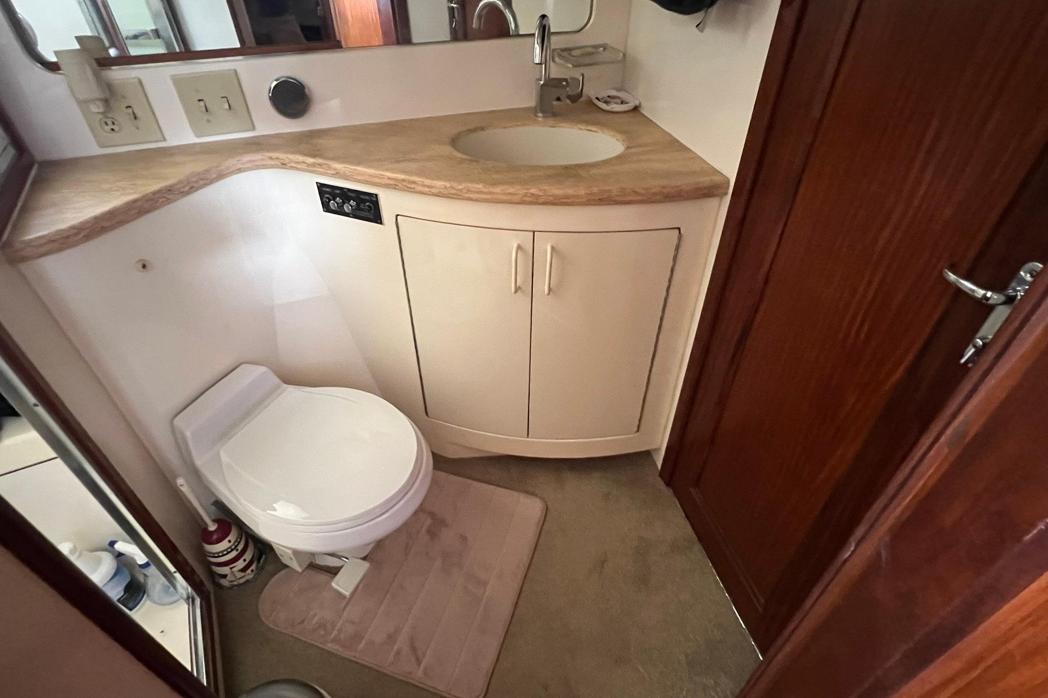 Bathroom interior of 1990 Hatteras 41 Convertible yacht, featuring sink and toilet.