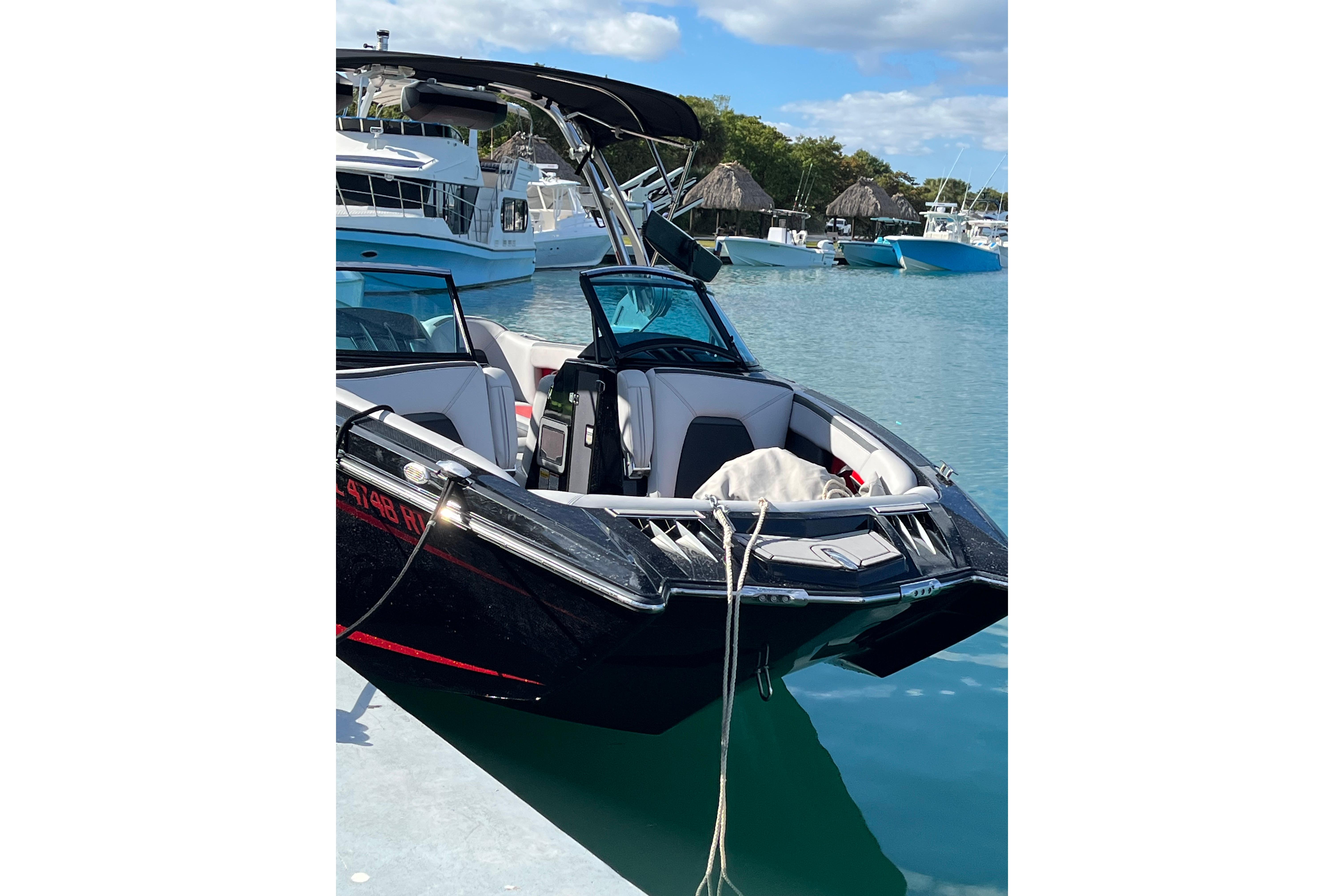 2019 MasterCraft XStar boat docked in a marina with clear blue water.