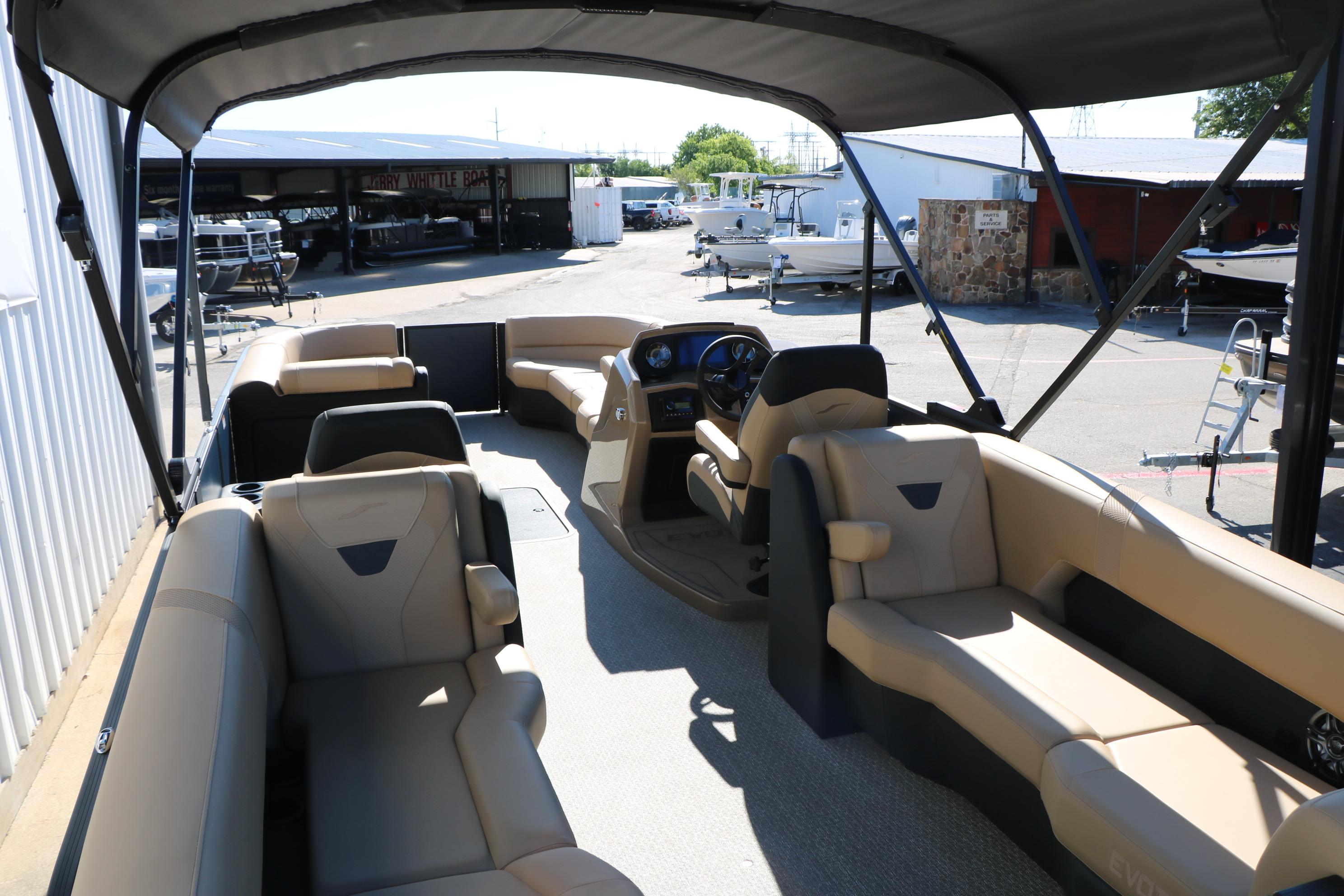 Interior of 2026 Evotti 525 QL Tri-Toon boat with beige seating and steering console.
