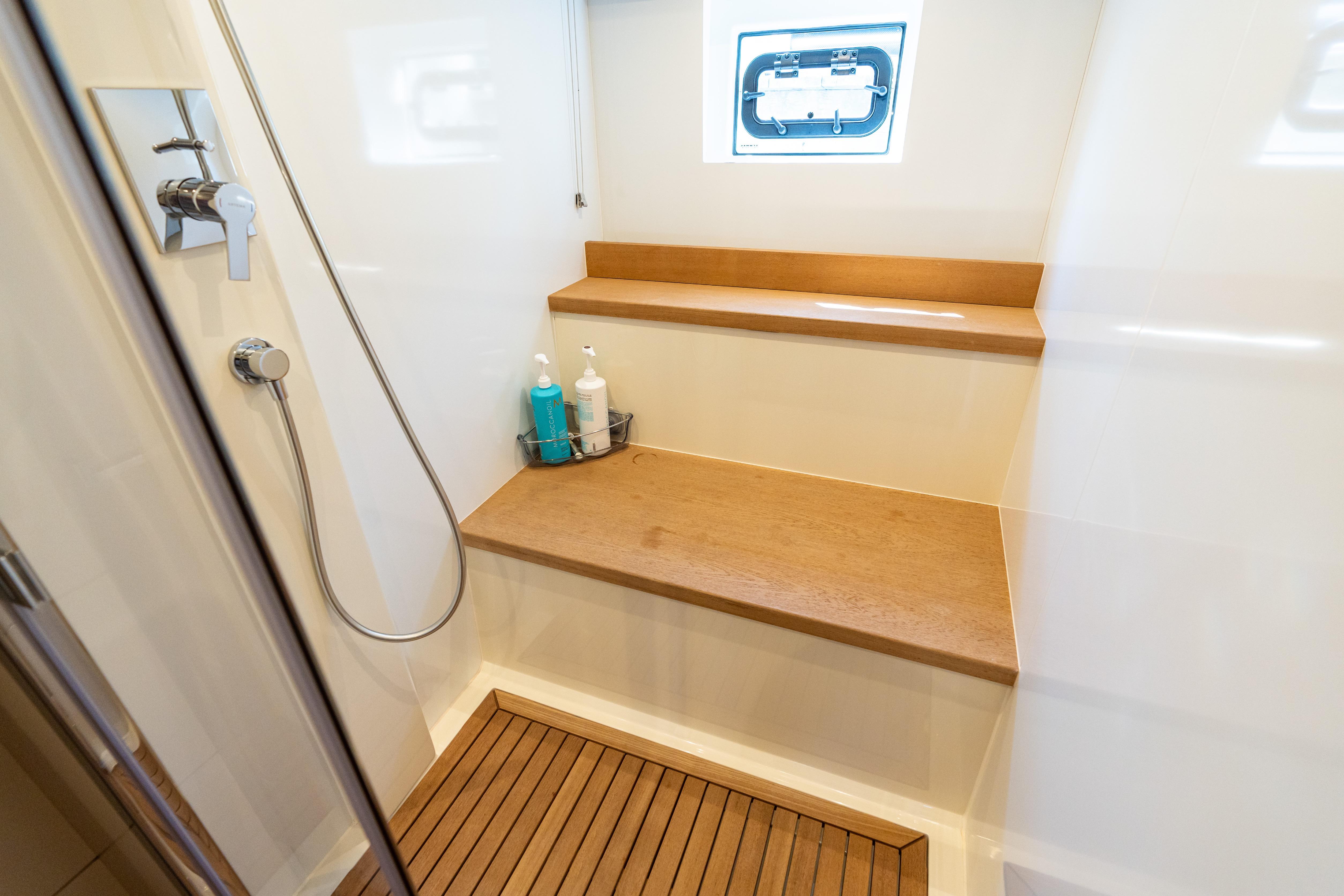 Shower area in 2019 Sirena 64 yacht with wooden bench and modern fixtures.