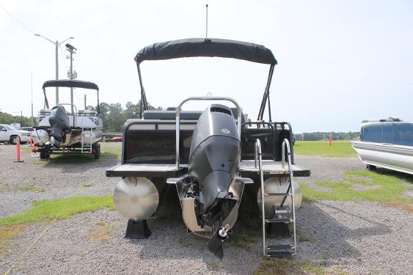 2025 Avalon LSZ Versatile Rear Lounger pontoon boat with outboard motor, parked on gravel.