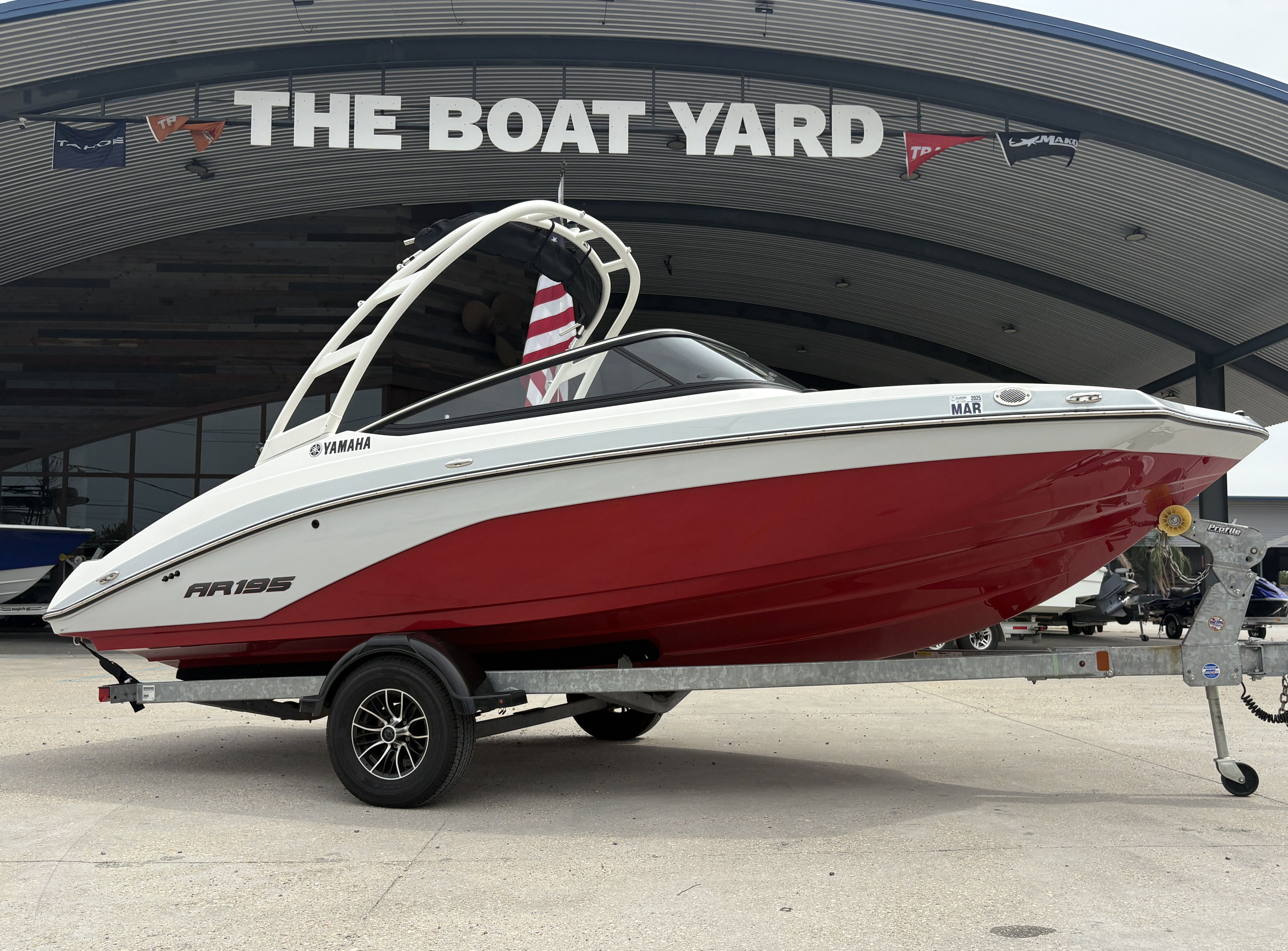 2024 Yamaha AR 195 boat with red hull on trailer at The Boat Yard.