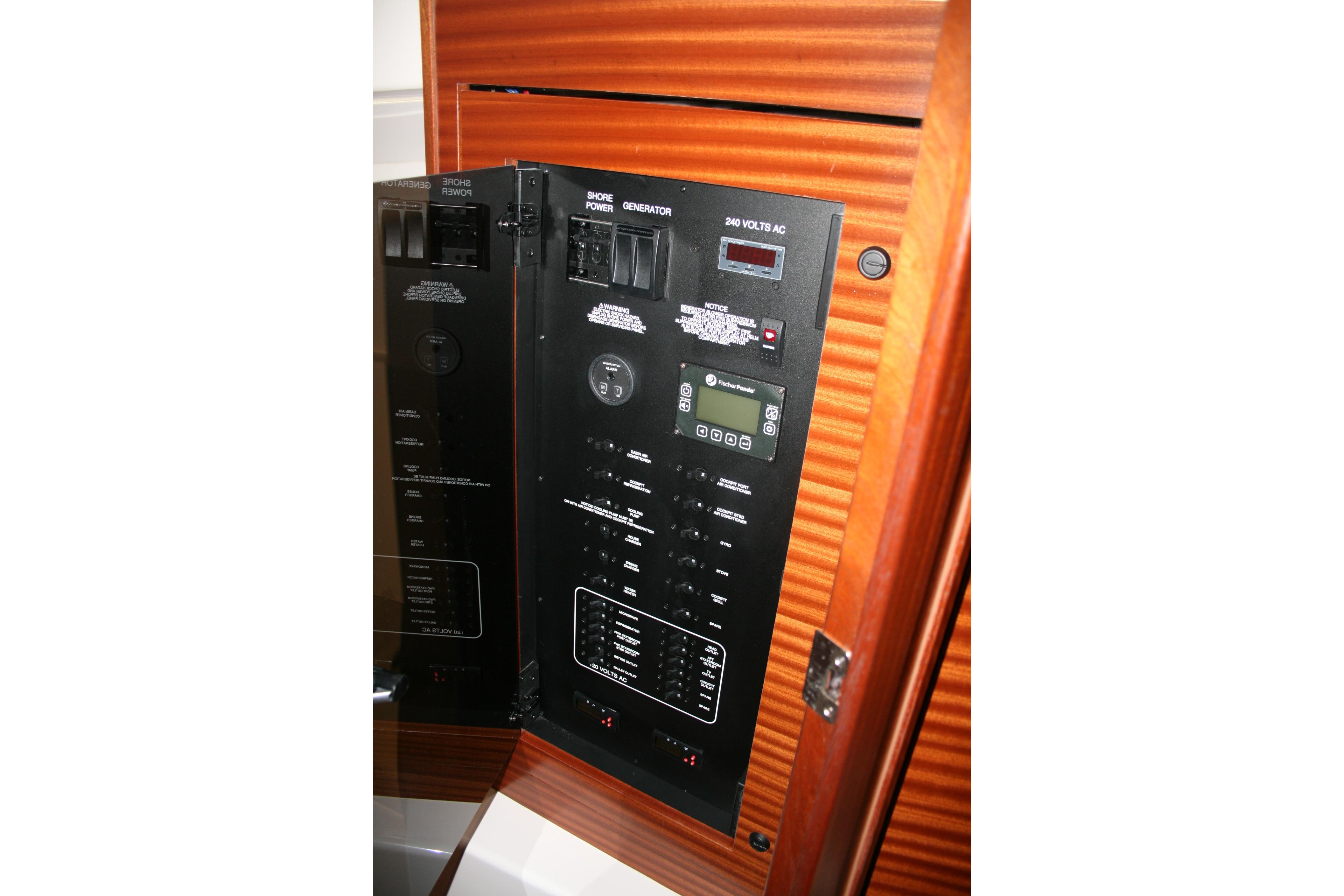 Electrical panel inside 2025 Pursuit OS 405 Offshore boat, featuring control switches and digital display.
