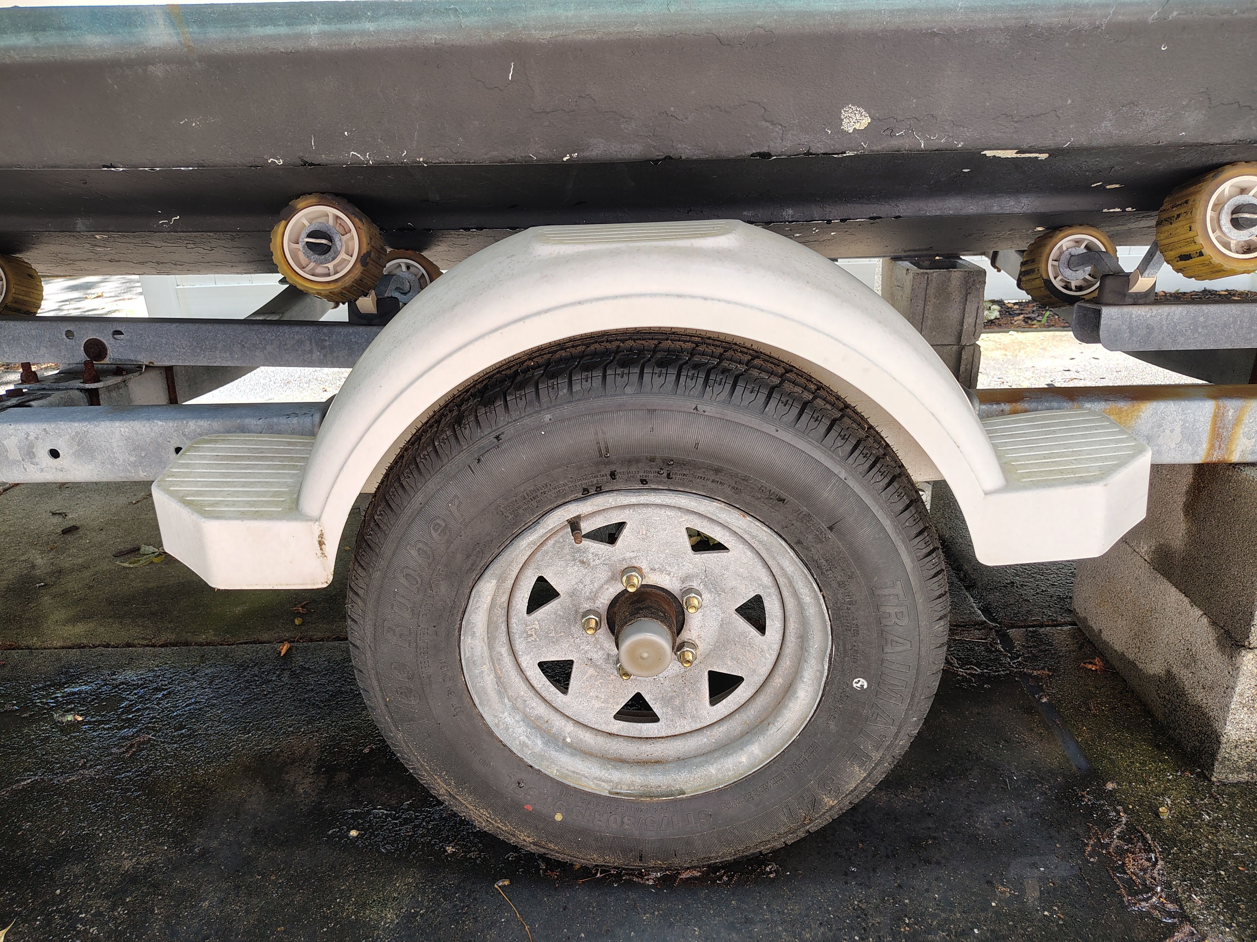 A boat trailer with a spare tire and wheel cover.