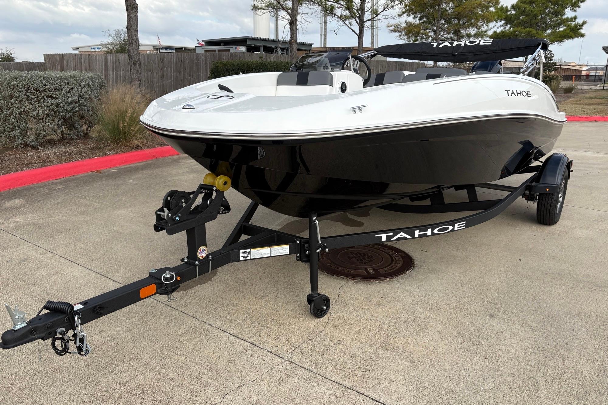 2025 Tahoe T16 boat on trailer, parked outdoors, showcasing sleek design and modern features.