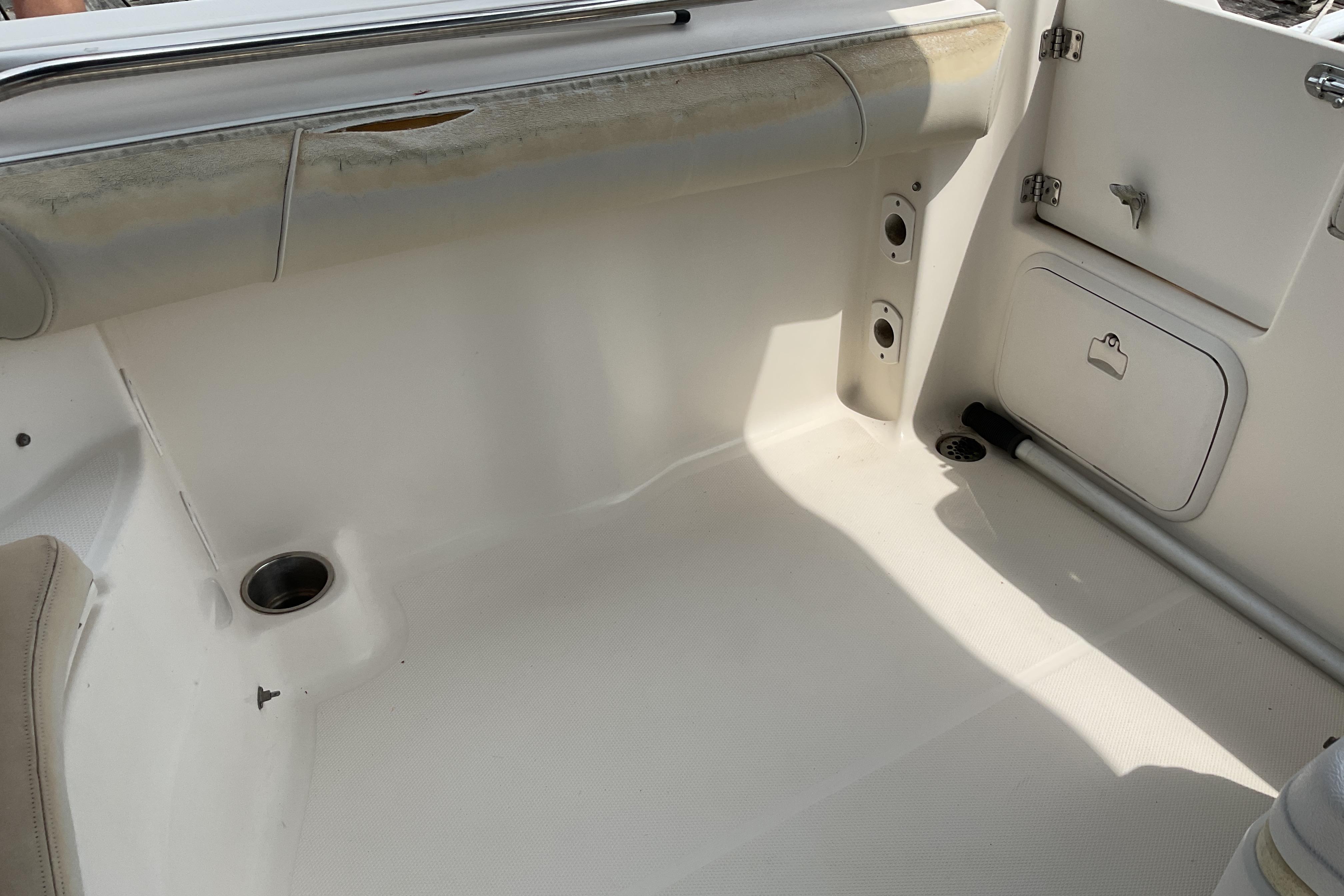 Interior view of a 2012 Wellcraft 232 Coastal boat, featuring storage compartments and seating area.
