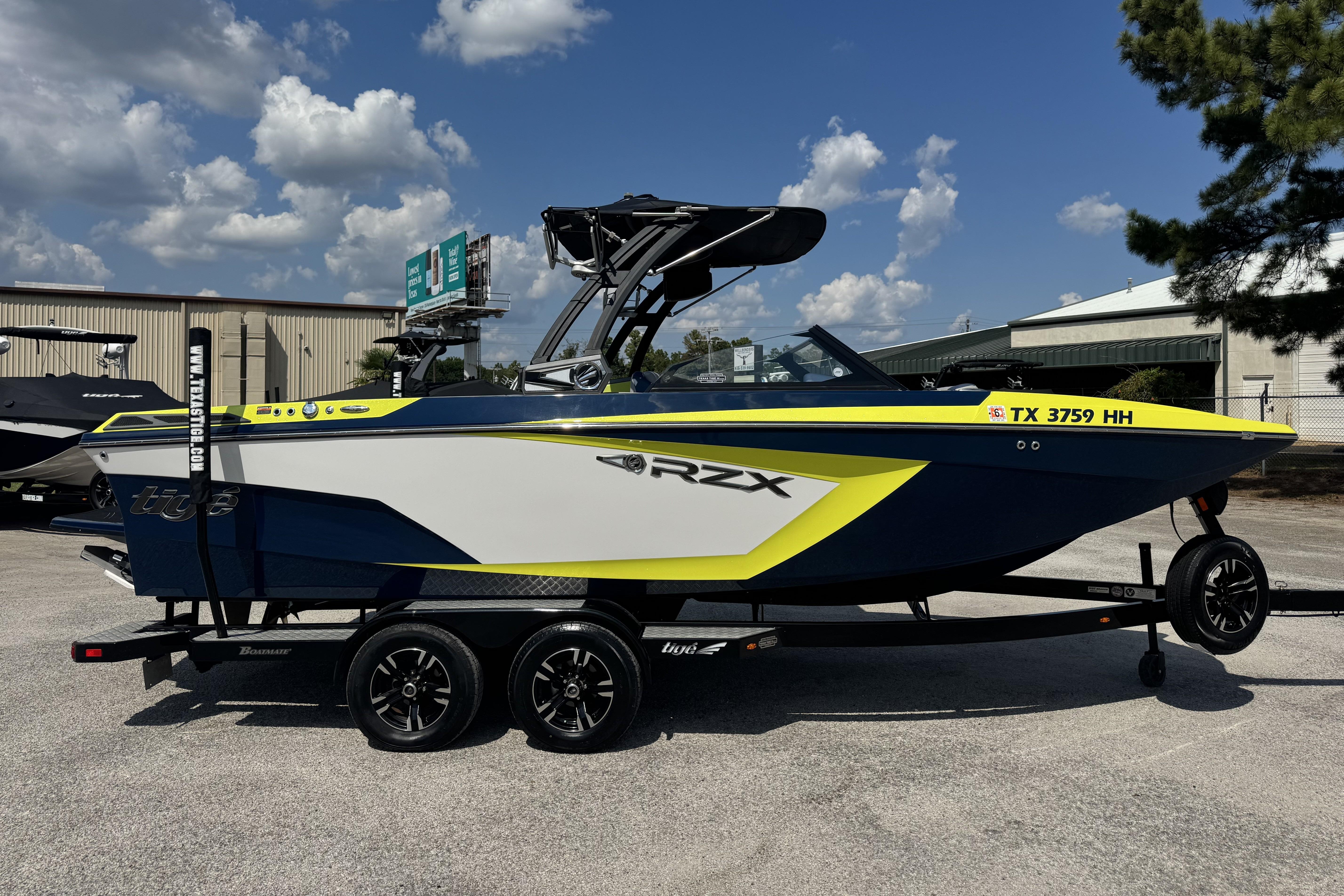 2020 Tigé 22RZX boat on trailer, blue and yellow design, parked outdoors.