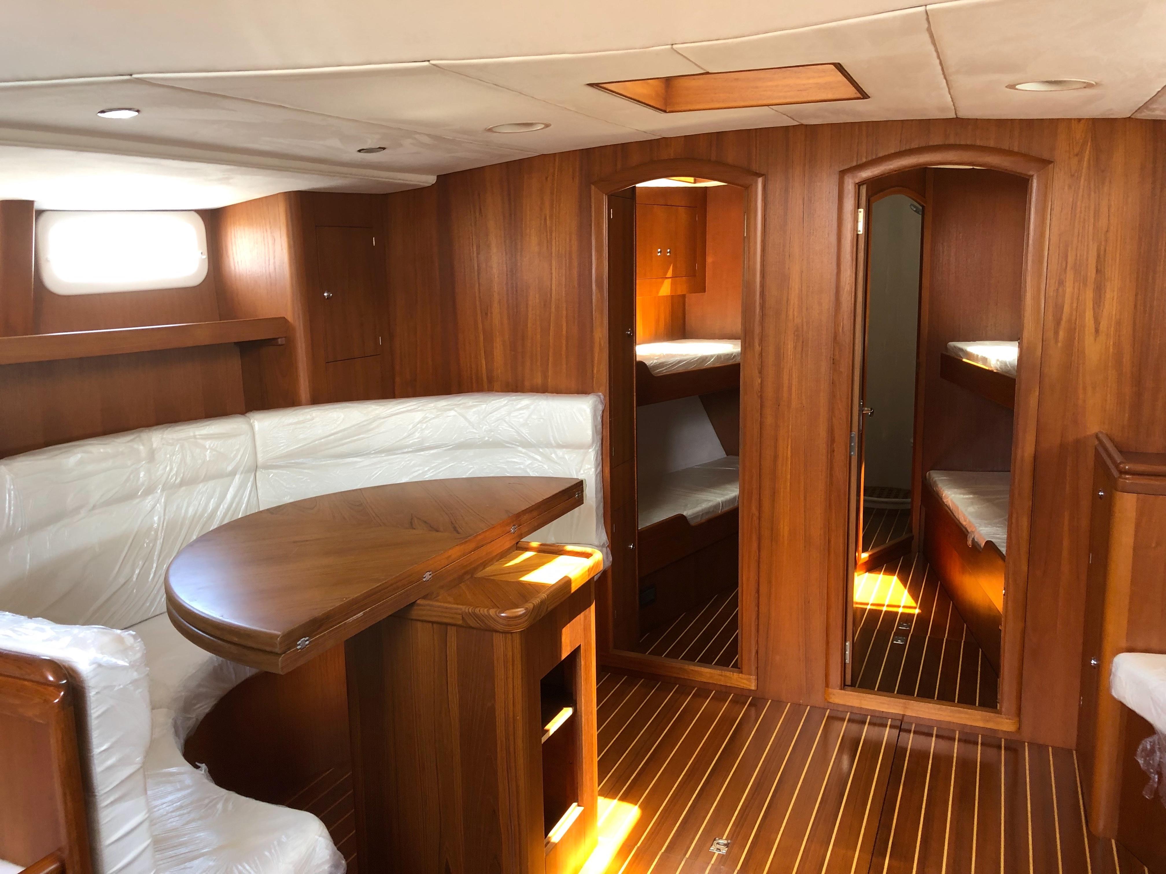 Luxurious interior of 2014 Van De Stadt Stainless Steel Cutter yacht with wooden finish and seating area.