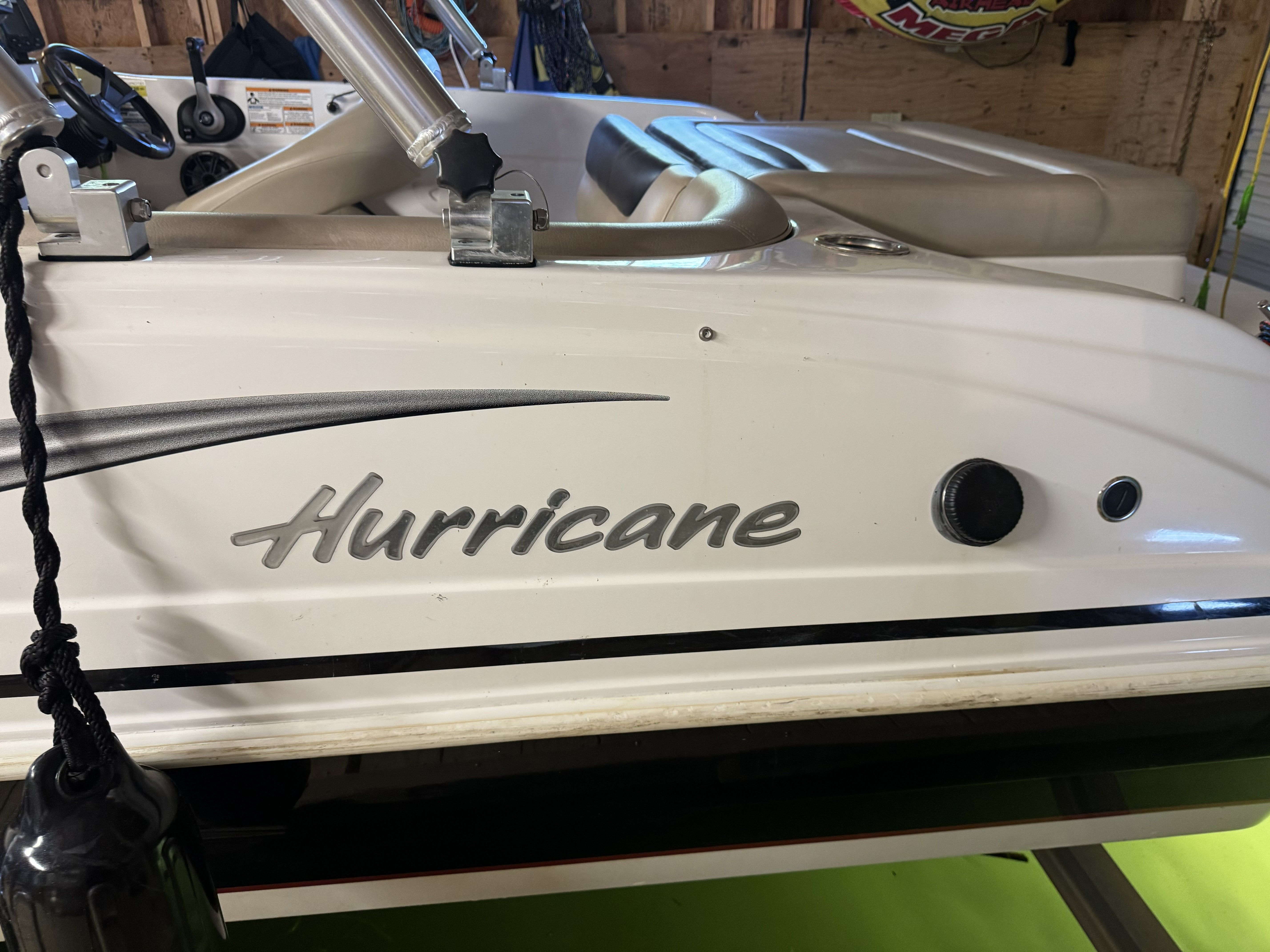 Close-up of a white Hurricane boat with black lettering in a garage.