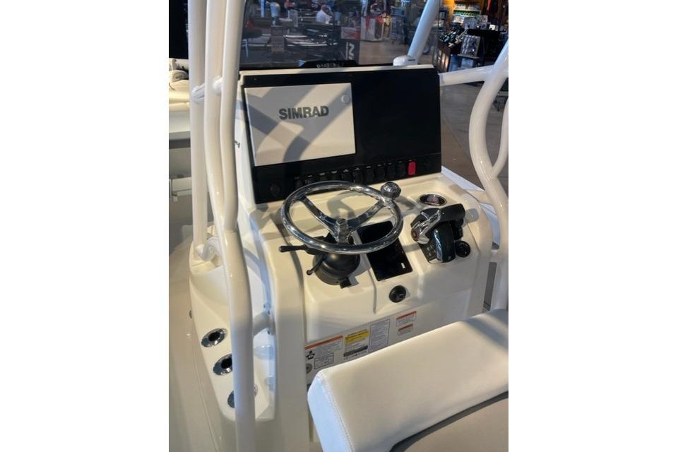 Control console of 2026 Mako 24 APEX boat with Simrad display and steering wheel.