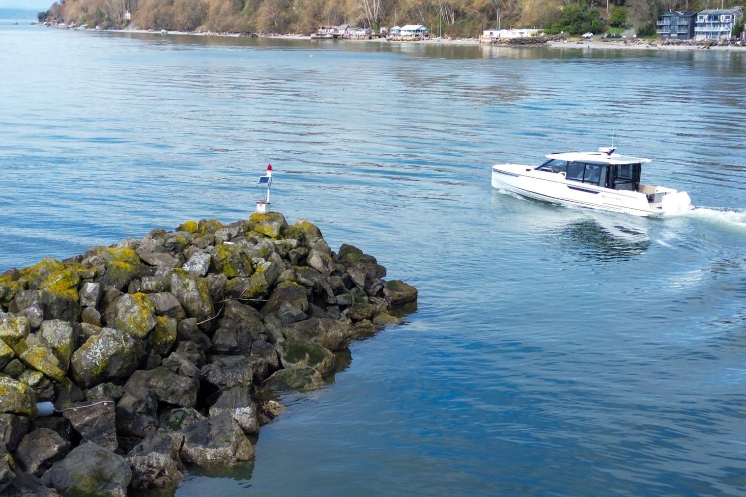 2026 Saxdor 400 GTC cruising near rocky shoreline on a calm day.