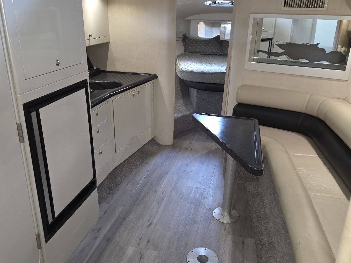 The interior of the 2000 Weldcraft Excalibur 45 features a modern cabin with a kitchenette, seating area, and bed.