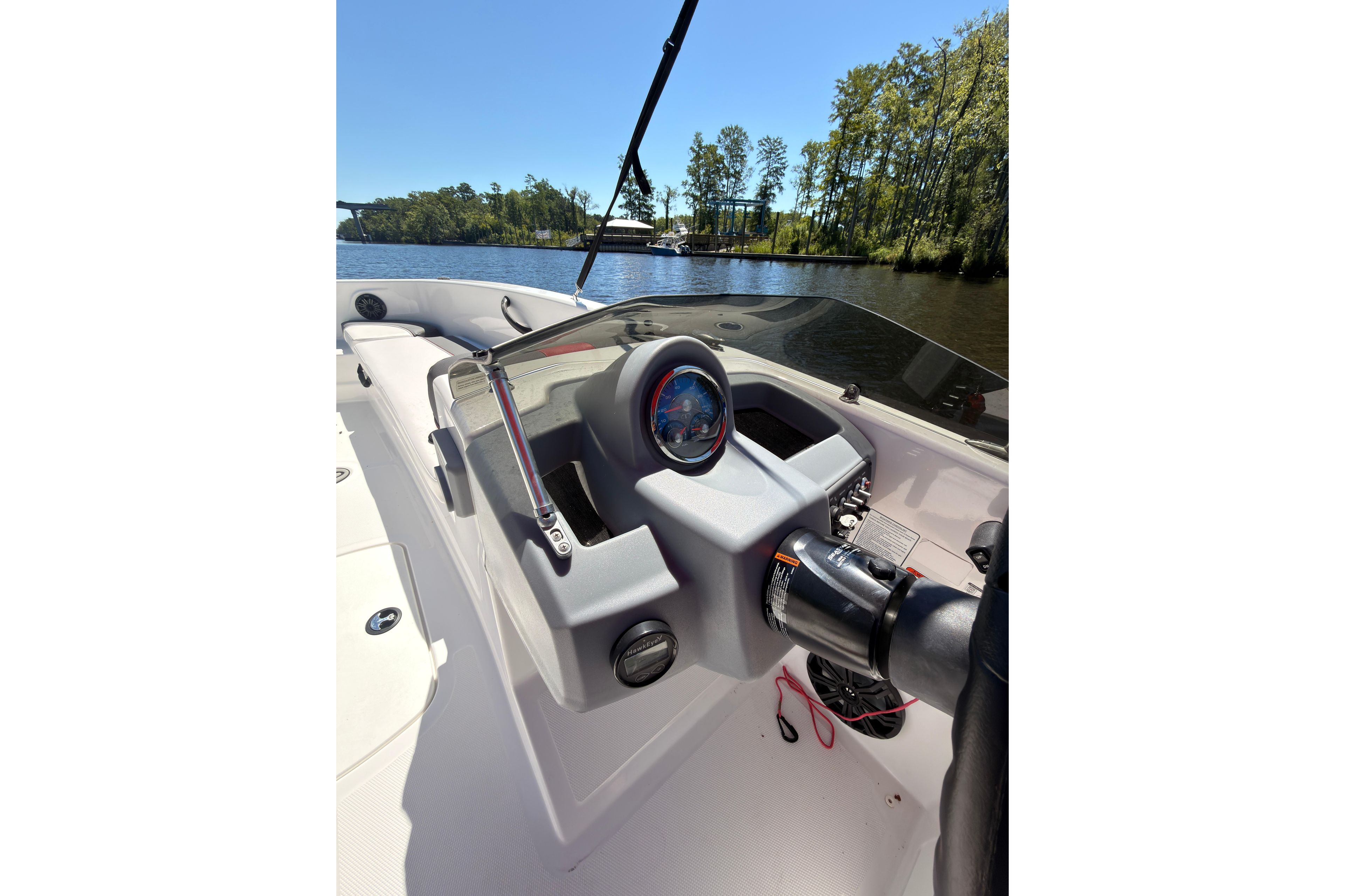 2022 Tahoe T18 boat dashboard with steering wheel, gauges, and scenic lake view.