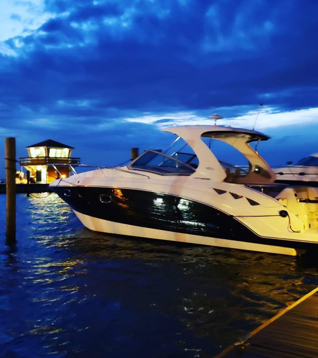 2014 Chaparral 330 Signature Cruiser docked at sunset with vibrant blue sky.
