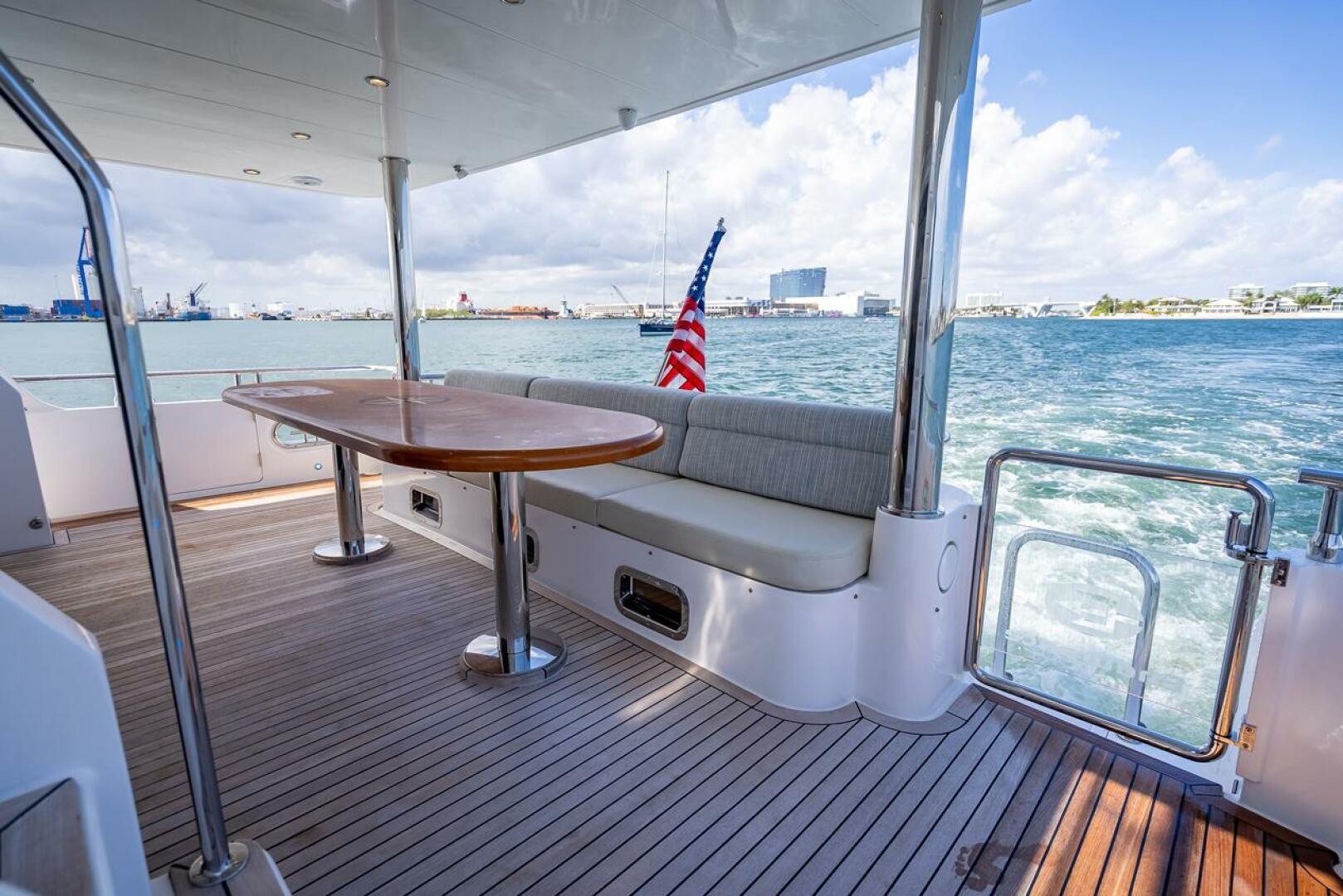 Luxurious 2022 Hampton 658l Endurance yacht deck with seating, table, and ocean view.